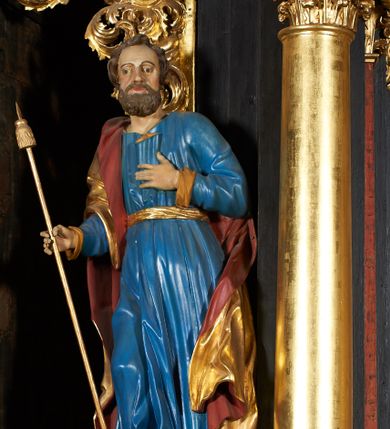 Zdjęcie nr 13: Nastawa architektoniczna, jednoosiowa, jednokondygnacyjna ze zwieńczeniem. Ołtarz prostopadłościenny, drewniany, mensa drewniana z kamiennym portatylem. Antepedium drewniane z malowaną dekoracją w postaci ramy i trzech pól z dekoracją roślinną; zwieńczone od góry lambrekinem. Nastawa ołtarzowa na podwójnym cokole, ujęta zwielokrotnionymi pilastrami, na tle których kolumny o kapitelach kompozytowych, dźwigające belkowanie wyłamane na ich osi o silnie wysuniętym gzymsie. W partii cokołu umieszczony jest obraz przedstawiający Chrystusa w grobie. Pole środkowe nastawy w kształcie stojącego prostokąta zakończonego łukiem półkolistym, w środku obraz „Przebicie włócznią”. Po bokach figury świętych: po lewej św. Jakuba Większego, a po prawej św. Filipa. Zwieńczenie w formie okrągłego pola obrazowego, obwiedzionego srebrną ramą imitującą wieniec laurowy oraz ażurowym, suchym akantem. Na belkowaniu, na osi kolumn ustawione anioły z arma Christi. W polu zwieńczenia obraz Matki Boskiej Bolesnej. Na szczycie figura Chrystusa. Dekorację ornamentalną nastawy stanowią w części dolnej cokołu girlandy, w części cokołowej zasadniczej nastawy liście akantu oraz uskrzydlone główki anielskie na tle akantu; w partii fryzu stylizowane liście akantu, nad kolumnami uskrzydlone główki anielskie. Kondygnacja ujęta uszami utworzonymi z ażurowego akantu. Ołtarz pokryty czarna polichromią z czerwonymi profilami; kolumny oraz partie ornamentalne złocone i srebrzone.