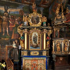 Zdjęcie nr 1: Nastawa architektoniczna, jednoosiowa, jednokondygnacyjna ze zwieńczeniem. Ołtarz prostopadłościenny, drewniany, mensa drewniana z kamiennym portatylem. Antepedium drewniane z malowaną dekoracją w postaci ramy i trzech pól z dekoracją roślinną i ptakami; zwieńczone od góry lambrekinem. W predelli obraz Zwiastowania Najświętszej Marii Pannie. Nastawa ołtarzowa na podwójnym cokole, ujęta zwielokrotnionymi pilastrami, na tle których kolumny o kapitelach kompozytowych, dźwigające belkowanie wyłamane na ich osi o silnie wysuniętym gzymsie. Pole środkowe w kształcie stojącego prostokąta zakończonego łukiem półkolistymi, w środku obraz Matki Boskiej Niepokalanie Poczętej. Po bokach figury: św. Piotra po lewej i św. Pawła po prawej. Zwieńczenie w formie okrągłego pola obrazowego obwiedzionego srebrną ramą imitującą wieniec laurowy oraz ażurowym, suchym akantem. W polu obraz z przedstawieniem Świętej Rodziny; na belkowaniu, na osi kolumn na postumentach figury aniołów. Dekorację ornamentalną nastawy stanowią w części dolnej cokołu girlandy, w części cokołowej zasadniczej nastawy liście akantu oraz uskrzydlone główki anielskie na tle akantu; w partii fryzu liście akantu, nad kolumnami uskrzydlone główki anielskie. Kondygnacja ujęta uszami utworzonymi z ażurowego akantu.  Zwieńczenie zakończone cokołem z figurą św. Michała Archanioła. Polichromia całości struktury ołtarza w kolorze czarnym, pilastry flankujące pole środkowe marmoryzowane w odcieniu czerwonym, profilowania i detal architektoniczny pozłacane i posrebrzane.