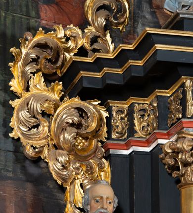 Zdjęcie nr 14: Nastawa architektoniczna, jednoosiowa, jednokondygnacyjna ze zwieńczeniem. Ołtarz prostopadłościenny, drewniany, mensa drewniana z kamiennym portatylem. Antepedium drewniane z malowaną dekoracją w postaci ramy i trzech pól z dekoracją roślinną i ptakami; zwieńczone od góry lambrekinem. W predelli obraz Zwiastowania Najświętszej Marii Pannie. Nastawa ołtarzowa na podwójnym cokole, ujęta zwielokrotnionymi pilastrami, na tle których kolumny o kapitelach kompozytowych, dźwigające belkowanie wyłamane na ich osi o silnie wysuniętym gzymsie. Pole środkowe w kształcie stojącego prostokąta zakończonego łukiem półkolistymi, w środku obraz Matki Boskiej Niepokalanie Poczętej. Po bokach figury: św. Piotra po lewej i św. Pawła po prawej. Zwieńczenie w formie okrągłego pola obrazowego obwiedzionego srebrną ramą imitującą wieniec laurowy oraz ażurowym, suchym akantem. W polu obraz z przedstawieniem Świętej Rodziny; na belkowaniu, na osi kolumn na postumentach figury aniołów. Dekorację ornamentalną nastawy stanowią w części dolnej cokołu girlandy, w części cokołowej zasadniczej nastawy liście akantu oraz uskrzydlone główki anielskie na tle akantu; w partii fryzu liście akantu, nad kolumnami uskrzydlone główki anielskie. Kondygnacja ujęta uszami utworzonymi z ażurowego akantu.  Zwieńczenie zakończone cokołem z figurą św. Michała Archanioła. Polichromia całości struktury ołtarza w kolorze czarnym, pilastry flankujące pole środkowe marmoryzowane w odcieniu czerwonym, profilowania i detal architektoniczny pozłacane i posrebrzane.