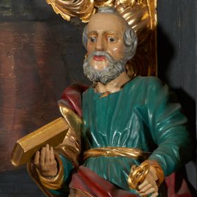 Zdjęcie nr 1: Rzeźba drążona, przedstawiająca św. Piotra. Święty ustawiony frontalnie w kontrapoście z lewą nogą ugiętą w kolanie, w lewej dłoni wyciągniętej przed siebie trzyma klucze, a w prawej zamkniętą księgę. Twarz pociągła o wyrazistych rysach, długim i prostym nosie, okolona krótką brodą, czoło wysokie z zakolami, oczy duże, nos wydatny, usta lekko rozchylone. Święty ubrany jest w długą, zieloną suknię, przewiązaną w pasie złotą szarfą oraz złoty płaszcz z czerwoną podszewką owinięty wokół prawego ramienia. Polichromia ciała naturalistyczna, płaszcz i atrybuty złocone.