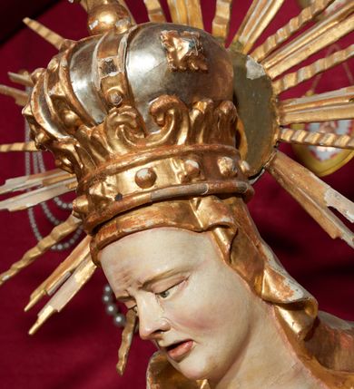 Zdjęcie nr 5: Siedząca figura Matki Boskiej zwrócona trzy czwarte w prawo, z pochyloną głową, podtrzymuje leżące na jej kolanach ciało martwego Chrystusa. Lewą ręką obejmuje jego ramię, prawą podtrzymuje głowę. Twarz Matki Boskiej szczupła o starczych rysach, oczy skierowane w dół, długi nos, rozchylone usta. Postać ubrana w złotą suknię o dekoracyjnie potraktowanych rękawach, silnie przylegającą do ciała w dolnej partii oraz obficie drapowany płaszcz przykrywający głowę i opadający na plecy. Na głowie dekoracyjna korona otoczona wokół niej promienistą glorią. Ciało Chrystusa opada bezwładnie, lewa ręka ugięta, prawa układa się wzdłuż boku Marii. Twarz ascetyczna, o wyraźnych rysach, zapadłych policzkach, oczy na wpół przymknięte, usta rozchylone; okolona zarostem. Włosy długie w postaci bujnych loków, opadają na ramiona; na głowie korona cierniowa w glorii. Ciało wychudłe, plastycznie kształtowane o wyrazistej anatomii z zaznaczonymi śladami męki, obficie broczącymi krwią. Przez biodra przepasane krótkie perizonium.
Polichromia naturalistyczna w partiach ciała, szaty złocone.