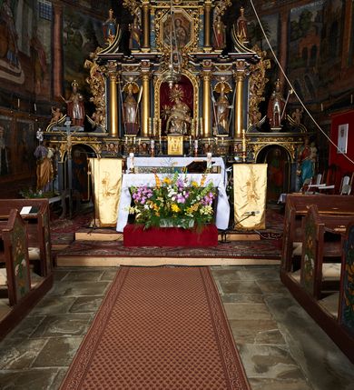 Zdjęcie nr 3: Nastawa ołtarzowa architektoniczna, trójosiowa, dwukondygnacyjna na cokole z bramkami. Ołtarz prostopadłościenny, drewniany. Mensa drewniana z kamiennym portatylem. Antepedium w formie leżącego prostokąta z przedstawieniem pelikana karmiącego młode. Całość ujęta bujną dekoracją roślinną z kwiatami ukazaną na złotym tle. U dołu napis: „A(NNO) D(OMINI) M C M X X I V”. Tabernakulum nowe w formie prostopadłościennej skrzynki. Na ściance frontowej drzwiczki w kształcie stojącego prostokąta zamkniętego łukiem nadwieszonym. W polu płaskorzeźbiony kielich z hostią oraz winna latorośl, powyżej dwa anioły. Nastawa ustawiona na zdwojonym cokole. Cokół dekorowany akantem mięsistym, owocowymi girlandami oraz uskrzydlonymi główkami anielskimi  na osi kolumn.

Osie pierwszej kondygnacji retabulum wydzielone czterema kolumnami o kapitelach korynckich ustawionymi na tle pilastrów, dźwigającymi pełne belkowanie zamknięte wydatnym gzymsem, wyłamane w partii podpór; nad polem środkowym przyjmujące formę łuku odcinkowego; na osi zewnętrznej pary podpór przerwany, odwrócony przyczółek. W polu środkowym rama w formie stojącego prostokąta zamkniętego łukiem półkolistym, w której umieszczona jest rzeźbiona Pieta. Na zasuwie obraz św. Jana Chrzciciela. Rama zdobiona ornamentem roślinnym, w przyłuczach uskrzydlone główki anielskie. Powyżej medalion z rzeźbioną głową św. Jana Chrzciciela na tacy w ramie z mięsistego, ażurowego akantu. W osiach bocznych płytkie nisze z figurami św. Wojciecha po lewej stronie i św. Stanisława po prawej. Nisze w osiach bocznych zamknięte konchą, ponad którą wstęga z koszem i owocami. Fryz dekorowany girlandami z tkaniny i owoców oraz uskrzydlonymi główkami anielskimi na osi podpór. Kondygnacja ujęta bujnymi uszami z ażurowego, suchego akantu. 

Druga kondygnacja szerokości osi środkowej, ujęta parą kolumn o kapitelach korynckich dźwigających pełne belkowanie z wydatnym gzymsem wyłamane na ich osi oraz przerwany przyczółek. W polu środkowym rama w formie stojącego prostokąta o ściętych narożach z obrazem Matki Boskiej. Kondygnacja flankowana przez figury św. Barbary po lewej stronie i św. Katarzyny po prawej. Z kolei na osi skrajnych kolumn, za przyczółkami ustawiona jest druga para dwóch świętych prawdopodobnie węgierskich. Fryz dekorowany akantem oraz uskrzydlonymi główkami anielskimi na osi podpór. Kondygnacja ujęta ażurowym suchym akantem. Na szczycie figura tronującej Matki Boskiej Królowej Niebios, stojącej na półksiężycu w glorii oraz dwa putta.
Bramki z przejściem w formie stojącego prostokąta zamkniętego łukiem półkolistym, ujęte pilastrami dźwigającymi niepełne belkowanie zamknięte silnie wystającym gzymsem i falistym, przerwanym przyczółkiem z siedzącymi puttami. Ponad bramkami na cokołach ustawione są figury św. Stefana po lewej stronie i św. Władysława po prawej. Drzwiczki bramek z malowanymi przedstawieniami św. Piotra po lewej stronie i św. Pawła po prawej. W przyłuczach i fryzie akant.
Nastawa marmoryzowana  w kolorze ciemnej zieleni ze złoconymi oraz srebrzonymi detalami architektonicznymi i ornamentyką. Na odwrociu ołtarza znajduje się malowidło przedstawiające św. Marię Magdalenę.