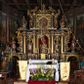 Zdjęcie nr 1: Nastawa ołtarzowa architektoniczna, trójosiowa, dwukondygnacyjna na cokole z bramkami. Ołtarz prostopadłościenny, drewniany. Mensa drewniana z kamiennym portatylem. Antepedium w formie leżącego prostokąta z przedstawieniem pelikana karmiącego młode. Całość ujęta bujną dekoracją roślinną z kwiatami ukazaną na złotym tle. U dołu napis: „A(NNO) D(OMINI) M C M X X I V”. Tabernakulum nowe w formie prostopadłościennej skrzynki. Na ściance frontowej drzwiczki w kształcie stojącego prostokąta zamkniętego łukiem nadwieszonym. W polu płaskorzeźbiony kielich z hostią oraz winna latorośl, powyżej dwa anioły. Nastawa ustawiona na zdwojonym cokole. Cokół dekorowany akantem mięsistym, owocowymi girlandami oraz uskrzydlonymi główkami anielskimi  na osi kolumn.

Osie pierwszej kondygnacji retabulum wydzielone czterema kolumnami o kapitelach korynckich ustawionymi na tle pilastrów, dźwigającymi pełne belkowanie zamknięte wydatnym gzymsem, wyłamane w partii podpór; nad polem środkowym przyjmujące formę łuku odcinkowego; na osi zewnętrznej pary podpór przerwany, odwrócony przyczółek. W polu środkowym rama w formie stojącego prostokąta zamkniętego łukiem półkolistym, w której umieszczona jest rzeźbiona Pieta. Na zasuwie obraz św. Jana Chrzciciela. Rama zdobiona ornamentem roślinnym, w przyłuczach uskrzydlone główki anielskie. Powyżej medalion z rzeźbioną głową św. Jana Chrzciciela na tacy w ramie z mięsistego, ażurowego akantu. W osiach bocznych płytkie nisze z figurami św. Wojciecha po lewej stronie i św. Stanisława po prawej. Nisze w osiach bocznych zamknięte konchą, ponad którą wstęga z koszem i owocami. Fryz dekorowany girlandami z tkaniny i owoców oraz uskrzydlonymi główkami anielskimi na osi podpór. Kondygnacja ujęta bujnymi uszami z ażurowego, suchego akantu. 

Druga kondygnacja szerokości osi środkowej, ujęta parą kolumn o kapitelach korynckich dźwigających pełne belkowanie z wydatnym gzymsem wyłamane na ich osi oraz przerwany przyczółek. W polu środkowym rama w formie stojącego prostokąta o ściętych narożach z obrazem Matki Boskiej. Kondygnacja flankowana przez figury św. Barbary po lewej stronie i św. Katarzyny po prawej. Z kolei na osi skrajnych kolumn, za przyczółkami ustawiona jest druga para dwóch świętych prawdopodobnie węgierskich. Fryz dekorowany akantem oraz uskrzydlonymi główkami anielskimi na osi podpór. Kondygnacja ujęta ażurowym suchym akantem. Na szczycie figura tronującej Matki Boskiej Królowej Niebios, stojącej na półksiężycu w glorii oraz dwa putta.
Bramki z przejściem w formie stojącego prostokąta zamkniętego łukiem półkolistym, ujęte pilastrami dźwigającymi niepełne belkowanie zamknięte silnie wystającym gzymsem i falistym, przerwanym przyczółkiem z siedzącymi puttami. Ponad bramkami na cokołach ustawione są figury św. Stefana po lewej stronie i św. Władysława po prawej. Drzwiczki bramek z malowanymi przedstawieniami św. Piotra po lewej stronie i św. Pawła po prawej. W przyłuczach i fryzie akant.
Nastawa marmoryzowana  w kolorze ciemnej zieleni ze złoconymi oraz srebrzonymi detalami architektonicznymi i ornamentyką. Na odwrociu ołtarza znajduje się malowidło przedstawiające św. Marię Magdalenę.