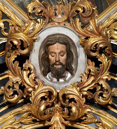 Zdjęcie nr 11: Nastawa ołtarzowa architektoniczna, trójosiowa, dwukondygnacyjna na cokole z bramkami. Ołtarz prostopadłościenny, drewniany. Mensa drewniana z kamiennym portatylem. Antepedium w formie leżącego prostokąta z przedstawieniem pelikana karmiącego młode. Całość ujęta bujną dekoracją roślinną z kwiatami ukazaną na złotym tle. U dołu napis: „A(NNO) D(OMINI) M C M X X I V”. Tabernakulum nowe w formie prostopadłościennej skrzynki. Na ściance frontowej drzwiczki w kształcie stojącego prostokąta zamkniętego łukiem nadwieszonym. W polu płaskorzeźbiony kielich z hostią oraz winna latorośl, powyżej dwa anioły. Nastawa ustawiona na zdwojonym cokole. Cokół dekorowany akantem mięsistym, owocowymi girlandami oraz uskrzydlonymi główkami anielskimi  na osi kolumn.

Osie pierwszej kondygnacji retabulum wydzielone czterema kolumnami o kapitelach korynckich ustawionymi na tle pilastrów, dźwigającymi pełne belkowanie zamknięte wydatnym gzymsem, wyłamane w partii podpór; nad polem środkowym przyjmujące formę łuku odcinkowego; na osi zewnętrznej pary podpór przerwany, odwrócony przyczółek. W polu środkowym rama w formie stojącego prostokąta zamkniętego łukiem półkolistym, w której umieszczona jest rzeźbiona Pieta. Na zasuwie obraz św. Jana Chrzciciela. Rama zdobiona ornamentem roślinnym, w przyłuczach uskrzydlone główki anielskie. Powyżej medalion z rzeźbioną głową św. Jana Chrzciciela na tacy w ramie z mięsistego, ażurowego akantu. W osiach bocznych płytkie nisze z figurami św. Wojciecha po lewej stronie i św. Stanisława po prawej. Nisze w osiach bocznych zamknięte konchą, ponad którą wstęga z koszem i owocami. Fryz dekorowany girlandami z tkaniny i owoców oraz uskrzydlonymi główkami anielskimi na osi podpór. Kondygnacja ujęta bujnymi uszami z ażurowego, suchego akantu. 

Druga kondygnacja szerokości osi środkowej, ujęta parą kolumn o kapitelach korynckich dźwigających pełne belkowanie z wydatnym gzymsem wyłamane na ich osi oraz przerwany przyczółek. W polu środkowym rama w formie stojącego prostokąta o ściętych narożach z obrazem Matki Boskiej. Kondygnacja flankowana przez figury św. Barbary po lewej stronie i św. Katarzyny po prawej. Z kolei na osi skrajnych kolumn, za przyczółkami ustawiona jest druga para dwóch świętych prawdopodobnie węgierskich. Fryz dekorowany akantem oraz uskrzydlonymi główkami anielskimi na osi podpór. Kondygnacja ujęta ażurowym suchym akantem. Na szczycie figura tronującej Matki Boskiej Królowej Niebios, stojącej na półksiężycu w glorii oraz dwa putta.
Bramki z przejściem w formie stojącego prostokąta zamkniętego łukiem półkolistym, ujęte pilastrami dźwigającymi niepełne belkowanie zamknięte silnie wystającym gzymsem i falistym, przerwanym przyczółkiem z siedzącymi puttami. Ponad bramkami na cokołach ustawione są figury św. Stefana po lewej stronie i św. Władysława po prawej. Drzwiczki bramek z malowanymi przedstawieniami św. Piotra po lewej stronie i św. Pawła po prawej. W przyłuczach i fryzie akant.
Nastawa marmoryzowana  w kolorze ciemnej zieleni ze złoconymi oraz srebrzonymi detalami architektonicznymi i ornamentyką. Na odwrociu ołtarza znajduje się malowidło przedstawiające św. Marię Magdalenę.