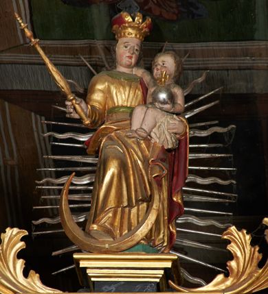 Zdjęcie nr 7: Nastawa ołtarzowa architektoniczna, trójosiowa, dwukondygnacyjna na cokole z bramkami. Ołtarz prostopadłościenny, drewniany. Mensa drewniana z kamiennym portatylem. Antepedium w formie leżącego prostokąta z przedstawieniem pelikana karmiącego młode. Całość ujęta bujną dekoracją roślinną z kwiatami ukazaną na złotym tle. U dołu napis: „A(NNO) D(OMINI) M C M X X I V”. Tabernakulum nowe w formie prostopadłościennej skrzynki. Na ściance frontowej drzwiczki w kształcie stojącego prostokąta zamkniętego łukiem nadwieszonym. W polu płaskorzeźbiony kielich z hostią oraz winna latorośl, powyżej dwa anioły. Nastawa ustawiona na zdwojonym cokole. Cokół dekorowany akantem mięsistym, owocowymi girlandami oraz uskrzydlonymi główkami anielskimi  na osi kolumn.

Osie pierwszej kondygnacji retabulum wydzielone czterema kolumnami o kapitelach korynckich ustawionymi na tle pilastrów, dźwigającymi pełne belkowanie zamknięte wydatnym gzymsem, wyłamane w partii podpór; nad polem środkowym przyjmujące formę łuku odcinkowego; na osi zewnętrznej pary podpór przerwany, odwrócony przyczółek. W polu środkowym rama w formie stojącego prostokąta zamkniętego łukiem półkolistym, w której umieszczona jest rzeźbiona Pieta. Na zasuwie obraz św. Jana Chrzciciela. Rama zdobiona ornamentem roślinnym, w przyłuczach uskrzydlone główki anielskie. Powyżej medalion z rzeźbioną głową św. Jana Chrzciciela na tacy w ramie z mięsistego, ażurowego akantu. W osiach bocznych płytkie nisze z figurami św. Wojciecha po lewej stronie i św. Stanisława po prawej. Nisze w osiach bocznych zamknięte konchą, ponad którą wstęga z koszem i owocami. Fryz dekorowany girlandami z tkaniny i owoców oraz uskrzydlonymi główkami anielskimi na osi podpór. Kondygnacja ujęta bujnymi uszami z ażurowego, suchego akantu. 

Druga kondygnacja szerokości osi środkowej, ujęta parą kolumn o kapitelach korynckich dźwigających pełne belkowanie z wydatnym gzymsem wyłamane na ich osi oraz przerwany przyczółek. W polu środkowym rama w formie stojącego prostokąta o ściętych narożach z obrazem Matki Boskiej. Kondygnacja flankowana przez figury św. Barbary po lewej stronie i św. Katarzyny po prawej. Z kolei na osi skrajnych kolumn, za przyczółkami ustawiona jest druga para dwóch świętych prawdopodobnie węgierskich. Fryz dekorowany akantem oraz uskrzydlonymi główkami anielskimi na osi podpór. Kondygnacja ujęta ażurowym suchym akantem. Na szczycie figura tronującej Matki Boskiej Królowej Niebios, stojącej na półksiężycu w glorii oraz dwa putta.
Bramki z przejściem w formie stojącego prostokąta zamkniętego łukiem półkolistym, ujęte pilastrami dźwigającymi niepełne belkowanie zamknięte silnie wystającym gzymsem i falistym, przerwanym przyczółkiem z siedzącymi puttami. Ponad bramkami na cokołach ustawione są figury św. Stefana po lewej stronie i św. Władysława po prawej. Drzwiczki bramek z malowanymi przedstawieniami św. Piotra po lewej stronie i św. Pawła po prawej. W przyłuczach i fryzie akant.
Nastawa marmoryzowana  w kolorze ciemnej zieleni ze złoconymi oraz srebrzonymi detalami architektonicznymi i ornamentyką. Na odwrociu ołtarza znajduje się malowidło przedstawiające św. Marię Magdalenę.