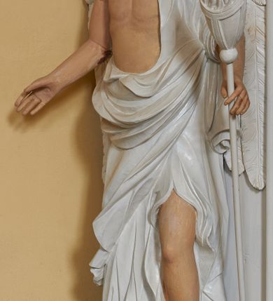 Zdjęcie nr 9: Nastawa ołtarzowa architektoniczna, jednoosiowa, dwukondygnacyjna, na cokole z bramkami. Ołtarz prostopadłościenny, drewniany; mensa drewniana. Antepedium w formie leżącego prostokąta, ujęte z trzech stron listwą o złoconym profilu, w centrum malowany złotem monogram maryjny. Tabernakulum w formie skrzynki o wklęsło-wypukłym wykroju, ustawione na profilowanym cokole, flankowane czterema kolumienkami o marmoryzowanych na niebiesko trzonach, podtrzymującymi niepełne belkowanie i wydatny gzyms. Ścianki boczne dekorowane prostokątnymi, marmoryzowanymi na niebiesko płycinami w złoconych ramach. Drzwiczki w kształcie stojącego prostokąta, zamkniętego łukiem nadwieszonym; w polu krucyfiks osadzony na wolutowej podstawie, od której odchodzą dwie gałązki akantu. Po bokach drzwiczek dwie wici roślinne. Tabernakulum flankują ustawione dwie figury aniołów.
Pierwsza kondygnacja retabulum ustawiona na cokole, ujęta parą filarów i stojących przed nimi, ustawionymi pod kątem kolumnami o kapitelach korynckich, dźwigających pełne belkowanie z wydatnym gzymsem. W polu środkowym rama w kształcie stojącego prostokąta zamkniętego trzema bokami z ośmioboku, dekorowana kampanulami, ujęta festonami z kampanulami, kwiatami i owocami. W polu obrazowym krucyfiks ukazany na malowanym tle Golgoty. Po bokach tabernakulum ustawione dwie figury: św. Jana Ewangelisty po lewej i św. Łukasza po prawej stronie.
Pośrodku belkowania zawieszone duże serce przebite sześcioma mieczami. Po jego bokach dwie rzeźby aniołków. Na gzymsie, na osi kolumny po prawej stronie ustawiona jest rzeźba św. Weroniki, a przed nią siedzący aniołek z trzema gwoździami w dłoni. Po lewej stronie św. Maria Magdalena, a przed nią aniołek z młotkiem w dłoni. 
Druga kondygnacja jest węższa, ujęta parą pilastrów i parą dostawionych pod kątem kolumn o kapitelach kompozytowych, dźwigających imposty. Cokoły kolumn i imposty ozdobione są z każdej strony uskrzydlonymi główkami aniołków. W polu rama w kształcie stojącego prostokąta o ściętych narożach, zdobiona ornamentem roślinnym, ujęta ornamentem z akantu i karbowanej wstęgi. Pośrodku promienista gloria z rzeźbioną gołębicą Ducha Świętego na tle obłoków. Całość zwieńczona drugą promienistą glorią z półpostacią Boga Ojca na tle obłoków. Po bokach na osi podpór siedzą dwie rzeźby aniołków. Obie kondygnacje ujęte są uszami utworzonymi z akantu i karbowanej wstęgi.
Bramki z przejściami w formie stojącego prostokąta o ściętych górnych narożach, zamknięte wydatnym gzymsem dźwiganym przez fragmenty pilastrów, na ich osi przerwany trójkątny przyczółek, zdobiony akantem. Przejścia flankowane figurami aniołów z arma Christi, nad bramkami figury proroków.
Struktura polichromowana na biało, ornamentyka i detale architektoniczne złocone i srebrzone.

