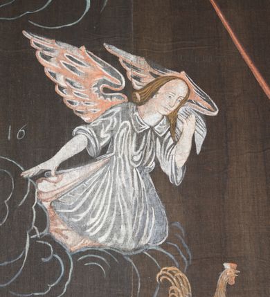 Zdjęcie nr 4: Tkanina wielkopostna przedstawiająca Piętę ukazaną na zszytych fragmentach płótna (25 brytów). W centrum kompozycji stoi krzyż, pod którym siedzi Matka Boska trzymająca na kolanach martwe ciało Chrystusa. Maria zwrócona jest trzy czwarte w lewo,  lewą ręką podtrzymuje rękę syna, prawą obejmuje go w talii, głowę ma przechyloną w lewo. Twarz podłużna o wyraźnych, konturowych rysach, oczy niemal zamknięte, długi nos, wąskie usta. Ubrana jest w jasną suknię o fałdach podkreślonych wyraźnymi konturami, niebieski płaszcz, okrywający nogi, podwikę oraz szary welon na głowie. Wokół głowy ma kolisty, złoty i promienisty nimb. Ciało Chrystusa spoczywa na kolanach Marii. Twarz owalna o konturowych rysach z zamkniętymi oczami, okolona jasnym zarostem, włosy długie z przedziałkiem na środku głowy, opadające na plecy. Ciało blade, ociekające krwią, niemodelowane, podkreślone konturem. Przez biodra przewiązane granatowe perizonium. O ramiona krzyża oparte ukośnie: po lewej włócznia, po prawej gąbka z octem na długim drzewcu. U góry krzyża zawieszony biały titulus w formie banderoli z tytułem winy w trzech językach „INRI”. Po bokach kompozycji u dołu, dwa anioły ukazane w pozycji klęczącej, zwrócone trzy czwarte ku środkowi obrazu. Anioł po prawej stronie trzyma w prawej dłoni drabinę, na której koniec założona jest korona cierniowa, nieco niżej ukazano trzy gwoździe, a wyżej rękawicę żołnierza. Anioł po lewej obejmuje kolumnę biczowania, na której stoi piejący kogut. W górnej części kolumny przywiązane są bicze. Ponad aniołami unoszą się na obłokach dwie kolejne postacie aniołów. Anioły ubrane są w różowe suknie i niebieskie tuniki z żółtą podszewką, przewiązane w pasie złotą taśmą. W górnych narożach obrazu symbole lunarne o ludzkich twarzach: po lewej księżyc, po prawej słońce. Na dole obrazu, pośrodku malowana na czerwono sygnatura „AB”. Po lewej stronie obrazu na wysokości ręki anioła unoszącego się na obłoku fragment daty „16”. Po bokach krzyża kilkuwersowe napisy, słabo czytelne. Według literatury nad głową Matki Boskiej znajduje się napis: „Filia populi ei acingere cilicio recospergere cinere: iuctu Unigenliafe tibi planctu emaru”.  Obok słońca i księżyca kolejny napis: „Ecce videntes clamabunt foris angeli pacis amare flebunt”, a także „amare flebunt angeli pacis”. Kolorystyka blada, w odcieniach zimnych, formy wydobyte konturem.