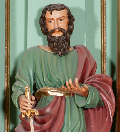 Zdjęcie nr 1: Rzeźba pełna, przedstawiająca św. Pawła. Święty ukazany frontalnie, z lewą ręką uniesioną na wysokość pasa, z mieczem skierowanym ku dołowi w prawej. Twarz szeroka o delikatnie rzeźbionych rysach, długim nosie i zmarszczonych brwiach, okolona brodą w postaci drobnych fal. Włosy półdługie, brązowe, nieznacznie kręcone. Święty ubrany jest w zieloną suknię, sięgającą połowy łydek, ze złotą lamówką u szyi oraz szarfą w talii; przepasany diagonalnie czerwonym płaszczem, opadającym z lewego ramienia na prawą nogę. Na nogach ma wiązane i złocone sandały.
Polichromia w odsłoniętych partiach ciała naturalistyczna, detale stroju złocone, miecz złocony i srebrzony.
