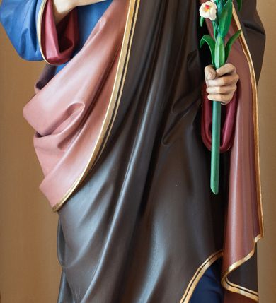 Zdjęcie nr 1: Rzeźba ustawiona na niskim, prostopadłościennym cokole o ściętych narożach, pomalowanym na kolor zielony. Święty Józef został ukazany w całej postaci, w postawie stojącej, w delikatnym kontrapoście, z lewą nogą ugiętą w kolanie, z prawą ręką złożoną na piersi, z gałązką białej lilii w lewej dłoni widocznej na wysokości biodra. Święty Józef ubrany jest w niebieską, długą suknię z czerwoną podszewką, z długimi rękawami oraz w brązowy płaszcz z różową podszewką. Szaty na brzegach złocone. Twarz szeroka, z długim i wąskim nosem, wzrokiem skierowanym w dół, okolona kędzierzawą, krótką brodą oraz średniej długości, ciemnymi włosami. Na dłoniach zaznaczone żyłkowanie. Polichromia w odsłoniętych partiach ciała naturalistyczna. 

