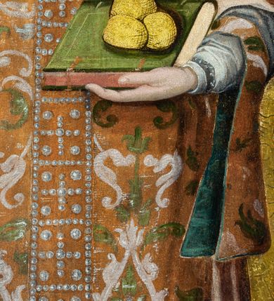 Zdjęcie nr 27: Ołtarz przyścienny, dwukondygnacyjny, jednoosiowy o formach architektonicznych; uszaty. Mensa drewniana, prostopadłościenna; antependium ujęte płaskorzeźbioną, złoconą ramą z dekoracją akantową. Lico malowane z monogramem maryjnym w otoczeniu barwnej dekoracji roślinno-kwiatowej na jasnobeżowym tle. W predelli rama w kształcie leżącego prostokąta ujęta ornamentem kartuszowym mieszcząca pierwotnie niezachowaną dekorację malarską. Nastawa ustawiona na wysokim cokole, ujęta kompozytowymi kolumnami dźwigającymi przełamujące się na osiach podpór pełne belkowanie z kostkowanym achitrawem, płaskorzeźbionym w motyw akantu i uskrzydlonych główek anielskich fryzem oraz wydatnym gzymsem. Kolumny w jednej trzeciej wysokości ujęte profilowanymi opaskami; trzony poniżej opasek zdobione motywem główek anielskich; powyżej płaskorzeźbiona dekoracja arabeskowa. W polu ołtarza prostokątna rama zamknięta łukiem półokrągłym mieszcząca obraz św. Mikołaja; w przyłuczach ramy umieszczone płaskorzeźbione, uskrzydlone główki anielskie. Kondygnacja druga ujęta hermowymi pilastrami dźwigającymi uproszczone belkowanie z wydatnym gzymsem. W polu obraz św. Benedykta o kształcie stojącego prostokąta w złoconej, profilowanej ramie. Na osiach kolumn, ustawione rzeźby św. Piotra (z prawej) i św. Pawła (z lewej) na tle esowatych wolut. Całość nastawy ujęta ażurowymi uszami utworzonymi z ornamentu okuciowego mieszczącymi nisze z rzeźbami św. Cecylii (z lewej) oraz św. Teresy z Avila (z prawej) umieszczonymi na tle muszli. Ponad niszami maszkarony trzymające w pyskach spływające do dołu draperie. Struktura ołtarza oraz partie szat postaci złocone; karnacje rzeźb polichromowane.
