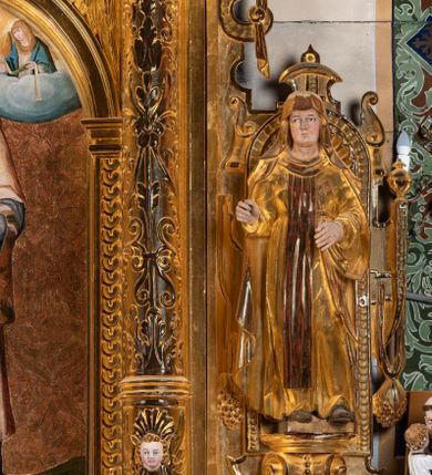 Zdjęcie nr 3: Ołtarz przyścienny, dwukondygnacyjny, jednoosiowy o formach architektonicznych; uszaty. Mensa drewniana, prostopadłościenna; antependium ujęte płaskorzeźbioną, złoconą ramą z dekoracją akantową. Lico malowane z monogramem maryjnym w otoczeniu barwnej dekoracji roślinno-kwiatowej na jasnobeżowym tle. W predelli rama w kształcie leżącego prostokąta ujęta ornamentem kartuszowym mieszcząca pierwotnie niezachowaną dekorację malarską. Nastawa ustawiona na wysokim cokole, ujęta kompozytowymi kolumnami dźwigającymi przełamujące się na osiach podpór pełne belkowanie z kostkowanym achitrawem, płaskorzeźbionym w motyw akantu i uskrzydlonych główek anielskich fryzem oraz wydatnym gzymsem. Kolumny w jednej trzeciej wysokości ujęte profilowanymi opaskami; trzony poniżej opasek zdobione motywem główek anielskich; powyżej płaskorzeźbiona dekoracja arabeskowa. W polu ołtarza prostokątna rama zamknięta łukiem półokrągłym mieszcząca obraz św. Mikołaja; w przyłuczach ramy umieszczone płaskorzeźbione, uskrzydlone główki anielskie. Kondygnacja druga ujęta hermowymi pilastrami dźwigającymi uproszczone belkowanie z wydatnym gzymsem. W polu obraz św. Benedykta o kształcie stojącego prostokąta w złoconej, profilowanej ramie. Na osiach kolumn, ustawione rzeźby św. Piotra (z prawej) i św. Pawła (z lewej) na tle esowatych wolut. Całość nastawy ujęta ażurowymi uszami utworzonymi z ornamentu okuciowego mieszczącymi nisze z rzeźbami św. Cecylii (z lewej) oraz św. Teresy z Avila (z prawej) umieszczonymi na tle muszli. Ponad niszami maszkarony trzymające w pyskach spływające do dołu draperie. Struktura ołtarza oraz partie szat postaci złocone; karnacje rzeźb polichromowane.
