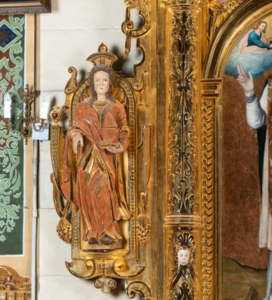 Zdjęcie nr 7: Ołtarz przyścienny, dwukondygnacyjny, jednoosiowy o formach architektonicznych; uszaty. Mensa drewniana, prostopadłościenna; antependium ujęte płaskorzeźbioną, złoconą ramą z dekoracją akantową. Lico malowane z monogramem maryjnym w otoczeniu barwnej dekoracji roślinno-kwiatowej na jasnobeżowym tle. W predelli rama w kształcie leżącego prostokąta ujęta ornamentem kartuszowym mieszcząca pierwotnie niezachowaną dekorację malarską. Nastawa ustawiona na wysokim cokole, ujęta kompozytowymi kolumnami dźwigającymi przełamujące się na osiach podpór pełne belkowanie z kostkowanym achitrawem, płaskorzeźbionym w motyw akantu i uskrzydlonych główek anielskich fryzem oraz wydatnym gzymsem. Kolumny w jednej trzeciej wysokości ujęte profilowanymi opaskami; trzony poniżej opasek zdobione motywem główek anielskich; powyżej płaskorzeźbiona dekoracja arabeskowa. W polu ołtarza prostokątna rama zamknięta łukiem półokrągłym mieszcząca obraz św. Mikołaja; w przyłuczach ramy umieszczone płaskorzeźbione, uskrzydlone główki anielskie. Kondygnacja druga ujęta hermowymi pilastrami dźwigającymi uproszczone belkowanie z wydatnym gzymsem. W polu obraz św. Benedykta o kształcie stojącego prostokąta w złoconej, profilowanej ramie. Na osiach kolumn, ustawione rzeźby św. Piotra (z prawej) i św. Pawła (z lewej) na tle esowatych wolut. Całość nastawy ujęta ażurowymi uszami utworzonymi z ornamentu okuciowego mieszczącymi nisze z rzeźbami św. Cecylii (z lewej) oraz św. Teresy z Avila (z prawej) umieszczonymi na tle muszli. Ponad niszami maszkarony trzymające w pyskach spływające do dołu draperie. Struktura ołtarza oraz partie szat postaci złocone; karnacje rzeźb polichromowane.
