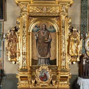 Zdjęcie nr 1: Ołtarz przyścienny, dwukondygnacyjny, jednoosiowy o formach architektonicznych; uszaty. Mensa drewniana, prostopadłościenna; antependium ujęte płaskorzeźbioną, złoconą ramą z dekoracją akantową. Lico malowane z monogramem maryjnym w otoczeniu barwnej dekoracji roślinno-kwiatowej na jasnobeżowym tle. W predelli rama w kształcie leżącego prostokąta ujęta ornamentem kartuszowym mieszcząca pierwotnie niezachowaną dekorację malarską. Nastawa ustawiona na wysokim cokole, ujęta kompozytowymi kolumnami dźwigającymi przełamujące się na osiach podpór pełne belkowanie z kostkowanym achitrawem, płaskorzeźbionym w motyw akantu i uskrzydlonych główek anielskich fryzem oraz wydatnym gzymsem. Kolumny w jednej trzeciej wysokości ujęte profilowanymi opaskami; trzony poniżej opasek zdobione motywem główek anielskich; powyżej płaskorzeźbiona dekoracja arabeskowa. W polu ołtarza prostokątna rama zamknięta łukiem półokrągłym mieszcząca obraz św. Mikołaja; w przyłuczach ramy umieszczone płaskorzeźbione, uskrzydlone główki anielskie. Kondygnacja druga ujęta hermowymi pilastrami dźwigającymi uproszczone belkowanie z wydatnym gzymsem. W polu obraz św. Benedykta o kształcie stojącego prostokąta w złoconej, profilowanej ramie. Na osiach kolumn, ustawione rzeźby św. Piotra (z prawej) i św. Pawła (z lewej) na tle esowatych wolut. Całość nastawy ujęta ażurowymi uszami utworzonymi z ornamentu okuciowego mieszczącymi nisze z rzeźbami św. Cecylii (z lewej) oraz św. Teresy z Avila (z prawej) umieszczonymi na tle muszli. Ponad niszami maszkarony trzymające w pyskach spływające do dołu draperie. Struktura ołtarza oraz partie szat postaci złocone; karnacje rzeźb polichromowane.
