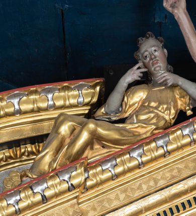 Zdjęcie nr 14: Nastawa ołtarzowa drewniana, architektoniczna, jednoosiowa, jednokondygnacyjna z predellą i zwieńczeniem. Retabulum na wysokim cokole zwieńczonym profilowanym gzymsem; lica wypełnione złoconym ornamentem kwiatowym i winnymi gronami. Predella srebrzona z rytym, złoconym ornamentem akantowym; za tabernakulum, na osi predelli wypukły kartusz z napisem: AVE REGINA COELORUM/ MATER REGIS ANGELORUM. O MARIA/ FLOS VIRGINUM/ VELUT ROSA VEL LILIUM/ FUNDE PRAECES AD FILIUM/ PRO SALUTE FIDELIUM. Nastawa ujęta parą zdwojonych kolumn o kompozytowych kapitelach; trzony w 1/3 wysokości przedzielone pierścieniem, w dolnej partii z dekoracją snycerską (płaskorzeźbione lwie główki, kaboszony, ornament okuciowy); w górnej części kanelowane. Kolumny podtrzymują pełne belkowanie przełamane na osi kolumn, zwieńczone trójkątnym, przerwanym przyczółkiem, na którym półleżące postacie aniołów. Na drugim planie, po bokach przyczółka profilowane, złocone spływy wolutowe. Gzymsy profilowane, złocone z kostkowaniem i kimationem. W zwieńczeniu, na osi ołtarza pełnoplastyczna, polichromowana figura Chrystusa Zmartwychwstałego. W polu środkowym ołtarza prostokątna, rozglifiona płycina w bogatym, płaskorzeźbionym i złoconym obramieniu mieszcząca obraz Matki Boskiej Niepokalanie Poczętej. W narożach obramienia płaskorzeźbione i polichromowane główki anielskie. Na podniebiu architrawu złocone róże umieszczone w prostokątnych kasetonach; w partii fryzu złocony ornament roślinny z umieszczonym na osi monogramem Marii. W polach na osi kolumn ornament kartuszowy z rautami (w osiach środkowych) oraz płaskorzeźbione i polichromowane główki kobiece (w osiach skrajnych). Tabernakulum drewniane o formach architektonicznych, z wypukłym licem, ustawione na mensie, na osi ołtarza na niewysokim, profilowanym i złoconym cokole, zwieńczone analogicznym gzymsem. Na drzwiczkach płaskorzeźbiony kielich z hostią. Struktura ołtarza polichromowana na kolor ciemnozielony z elementami ciemnej czerwieni i złocona; partie ornamentów i załamania profili architektonicznych złocone. 