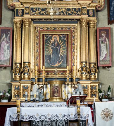 Zdjęcie nr 13: Nastawa ołtarzowa drewniana, architektoniczna, jednoosiowa, jednokondygnacyjna z predellą i zwieńczeniem. Retabulum na wysokim cokole zwieńczonym profilowanym gzymsem; lica wypełnione złoconym ornamentem kwiatowym i winnymi gronami. Predella srebrzona z rytym, złoconym ornamentem akantowym; za tabernakulum, na osi predelli wypukły kartusz z napisem: AVE REGINA COELORUM/ MATER REGIS ANGELORUM. O MARIA/ FLOS VIRGINUM/ VELUT ROSA VEL LILIUM/ FUNDE PRAECES AD FILIUM/ PRO SALUTE FIDELIUM. Nastawa ujęta parą zdwojonych kolumn o kompozytowych kapitelach; trzony w 1/3 wysokości przedzielone pierścieniem, w dolnej partii z dekoracją snycerską (płaskorzeźbione lwie główki, kaboszony, ornament okuciowy); w górnej części kanelowane. Kolumny podtrzymują pełne belkowanie przełamane na osi kolumn, zwieńczone trójkątnym, przerwanym przyczółkiem, na którym półleżące postacie aniołów. Na drugim planie, po bokach przyczółka profilowane, złocone spływy wolutowe. Gzymsy profilowane, złocone z kostkowaniem i kimationem. W zwieńczeniu, na osi ołtarza pełnoplastyczna, polichromowana figura Chrystusa Zmartwychwstałego. W polu środkowym ołtarza prostokątna, rozglifiona płycina w bogatym, płaskorzeźbionym i złoconym obramieniu mieszcząca obraz Matki Boskiej Niepokalanie Poczętej. W narożach obramienia płaskorzeźbione i polichromowane główki anielskie. Na podniebiu architrawu złocone róże umieszczone w prostokątnych kasetonach; w partii fryzu złocony ornament roślinny z umieszczonym na osi monogramem Marii. W polach na osi kolumn ornament kartuszowy z rautami (w osiach środkowych) oraz płaskorzeźbione i polichromowane główki kobiece (w osiach skrajnych). Tabernakulum drewniane o formach architektonicznych, z wypukłym licem, ustawione na mensie, na osi ołtarza na niewysokim, profilowanym i złoconym cokole, zwieńczone analogicznym gzymsem. Na drzwiczkach płaskorzeźbiony kielich z hostią. Struktura ołtarza polichromowana na kolor ciemnozielony z elementami ciemnej czerwieni i złocona; partie ornamentów i załamania profili architektonicznych złocone. 