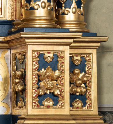 Zdjęcie nr 8: Nastawa ołtarzowa drewniana, architektoniczna, jednoosiowa, jednokondygnacyjna z predellą i zwieńczeniem. Retabulum na wysokim cokole zwieńczonym profilowanym gzymsem; lica wypełnione złoconym ornamentem kwiatowym i winnymi gronami. Predella srebrzona z rytym, złoconym ornamentem akantowym; za tabernakulum, na osi predelli wypukły kartusz z napisem: AVE REGINA COELORUM/ MATER REGIS ANGELORUM. O MARIA/ FLOS VIRGINUM/ VELUT ROSA VEL LILIUM/ FUNDE PRAECES AD FILIUM/ PRO SALUTE FIDELIUM. Nastawa ujęta parą zdwojonych kolumn o kompozytowych kapitelach; trzony w 1/3 wysokości przedzielone pierścieniem, w dolnej partii z dekoracją snycerską (płaskorzeźbione lwie główki, kaboszony, ornament okuciowy); w górnej części kanelowane. Kolumny podtrzymują pełne belkowanie przełamane na osi kolumn, zwieńczone trójkątnym, przerwanym przyczółkiem, na którym półleżące postacie aniołów. Na drugim planie, po bokach przyczółka profilowane, złocone spływy wolutowe. Gzymsy profilowane, złocone z kostkowaniem i kimationem. W zwieńczeniu, na osi ołtarza pełnoplastyczna, polichromowana figura Chrystusa Zmartwychwstałego. W polu środkowym ołtarza prostokątna, rozglifiona płycina w bogatym, płaskorzeźbionym i złoconym obramieniu mieszcząca obraz Matki Boskiej Niepokalanie Poczętej. W narożach obramienia płaskorzeźbione i polichromowane główki anielskie. Na podniebiu architrawu złocone róże umieszczone w prostokątnych kasetonach; w partii fryzu złocony ornament roślinny z umieszczonym na osi monogramem Marii. W polach na osi kolumn ornament kartuszowy z rautami (w osiach środkowych) oraz płaskorzeźbione i polichromowane główki kobiece (w osiach skrajnych). Tabernakulum drewniane o formach architektonicznych, z wypukłym licem, ustawione na mensie, na osi ołtarza na niewysokim, profilowanym i złoconym cokole, zwieńczone analogicznym gzymsem. Na drzwiczkach płaskorzeźbiony kielich z hostią. Struktura ołtarza polichromowana na kolor ciemnozielony z elementami ciemnej czerwieni i złocona; partie ornamentów i załamania profili architektonicznych złocone. 