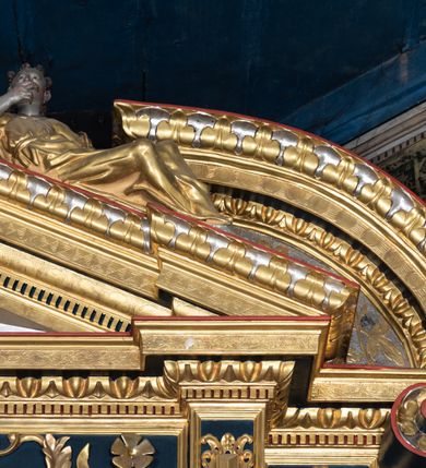 Zdjęcie nr 19: Nastawa ołtarzowa drewniana, architektoniczna, jednoosiowa, jednokondygnacyjna z predellą i zwieńczeniem. Retabulum na wysokim cokole zwieńczonym profilowanym gzymsem; lica wypełnione złoconym ornamentem kwiatowym i winnymi gronami. Predella srebrzona z rytym, złoconym ornamentem akantowym; za tabernakulum, na osi predelli wypukły kartusz z napisem: AVE REGINA COELORUM/ MATER REGIS ANGELORUM. O MARIA/ FLOS VIRGINUM/ VELUT ROSA VEL LILIUM/ FUNDE PRAECES AD FILIUM/ PRO SALUTE FIDELIUM. Nastawa ujęta parą zdwojonych kolumn o kompozytowych kapitelach; trzony w 1/3 wysokości przedzielone pierścieniem, w dolnej partii z dekoracją snycerską (płaskorzeźbione lwie główki, kaboszony, ornament okuciowy); w górnej części kanelowane. Kolumny podtrzymują pełne belkowanie przełamane na osi kolumn, zwieńczone trójkątnym, przerwanym przyczółkiem, na którym półleżące postacie aniołów. Na drugim planie, po bokach przyczółka profilowane, złocone spływy wolutowe. Gzymsy profilowane, złocone z kostkowaniem i kimationem. W zwieńczeniu, na osi ołtarza pełnoplastyczna, polichromowana figura Chrystusa Zmartwychwstałego. W polu środkowym ołtarza prostokątna, rozglifiona płycina w bogatym, płaskorzeźbionym i złoconym obramieniu mieszcząca obraz Matki Boskiej Niepokalanie Poczętej. W narożach obramienia płaskorzeźbione i polichromowane główki anielskie. Na podniebiu architrawu złocone róże umieszczone w prostokątnych kasetonach; w partii fryzu złocony ornament roślinny z umieszczonym na osi monogramem Marii. W polach na osi kolumn ornament kartuszowy z rautami (w osiach środkowych) oraz płaskorzeźbione i polichromowane główki kobiece (w osiach skrajnych). Tabernakulum drewniane o formach architektonicznych, z wypukłym licem, ustawione na mensie, na osi ołtarza na niewysokim, profilowanym i złoconym cokole, zwieńczone analogicznym gzymsem. Na drzwiczkach płaskorzeźbiony kielich z hostią. Struktura ołtarza polichromowana na kolor ciemnozielony z elementami ciemnej czerwieni i złocona; partie ornamentów i załamania profili architektonicznych złocone. 