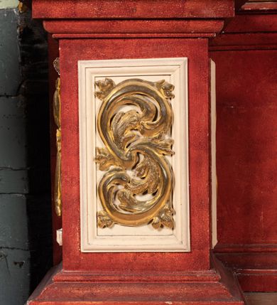 Zdjęcie nr 20: Ołtarz przyścienny o formach architektonicznych, jednoosiowy, jednokondygnacyjny ze zwieńczeniem; ujęty akantowymi uszami. Mensa prostopadłościenna; antepedium malowane w symetryczne motywy roślinno-kwiatowe na jasnobeżowym tle; ujęte złoconą ramą w kształcie leżącego prostokąta o wypukłych krótszych bokach. Nastawa ujęta parą kolumn umieszczonych na wysokich, prostopadłościennych postumentach. Trzony kolumn skręcone, oplecione kwiatowymi girlandami; kapitele kompozytowe, złocone. W polu ołtarza złocona, profilowana rama w kształcie stojącego prostokąta, mieszcząca obraz z przedstawieniem św. Józefa. Kolumny dźwigają pełne belkowanie przełamane na osiach podpór oraz odcinki trójkątnego przyczółka, na których pełnoplastyczne figurki aniołów. W partii fryzu złocony ornament akantowy oraz rozetki. Zwieńczenie w kształcie równoramiennego trapezu o wklęsłych bokach, zamknięte od góry gzymsem wklęsło-wypukłym. W polu owalna, złocona rama w formie wieńca laurowego mieszcząca obraz przedstawiający św. Jana Ewangelistę, ponad którym owalny, akantowy kartusz z napisem „IN / HONOREM S(ANCTI) JOSEPHI / ANNO DOMINI 1528”. Nastawa ujęta ażurowymi, złoconymi i srebrzonymi uszami utworzonymi z suchego akantu. Struktura ołtarza marmoryzowana w odcieniach czerwieni; dekoracja snycerska srebrzona i złocona, trzony kolumn czarne.
