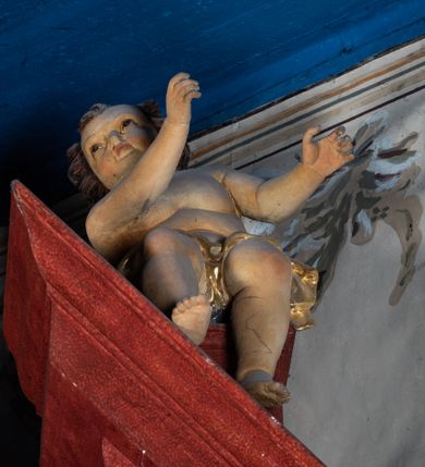 Zdjęcie nr 11: Ołtarz przyścienny o formach architektonicznych, jednoosiowy, jednokondygnacyjny ze zwieńczeniem; ujęty akantowymi uszami. Mensa prostopadłościenna; antepedium malowane w symetryczne motywy roślinno-kwiatowe na jasnobeżowym tle; ujęte złoconą ramą w kształcie leżącego prostokąta o wypukłych krótszych bokach. Nastawa ujęta parą kolumn umieszczonych na wysokich, prostopadłościennych postumentach. Trzony kolumn skręcone, oplecione kwiatowymi girlandami; kapitele kompozytowe, złocone. W polu ołtarza złocona, profilowana rama w kształcie stojącego prostokąta, mieszcząca obraz z przedstawieniem św. Józefa. Kolumny dźwigają pełne belkowanie przełamane na osiach podpór oraz odcinki trójkątnego przyczółka, na których pełnoplastyczne figurki aniołów. W partii fryzu złocony ornament akantowy oraz rozetki. Zwieńczenie w kształcie równoramiennego trapezu o wklęsłych bokach, zamknięte od góry gzymsem wklęsło-wypukłym. W polu owalna, złocona rama w formie wieńca laurowego mieszcząca obraz przedstawiający św. Jana Ewangelistę, ponad którym owalny, akantowy kartusz z napisem „IN / HONOREM S(ANCTI) JOSEPHI / ANNO DOMINI 1528”. Nastawa ujęta ażurowymi, złoconymi i srebrzonymi uszami utworzonymi z suchego akantu. Struktura ołtarza marmoryzowana w odcieniach czerwieni; dekoracja snycerska srebrzona i złocona, trzony kolumn czarne.
