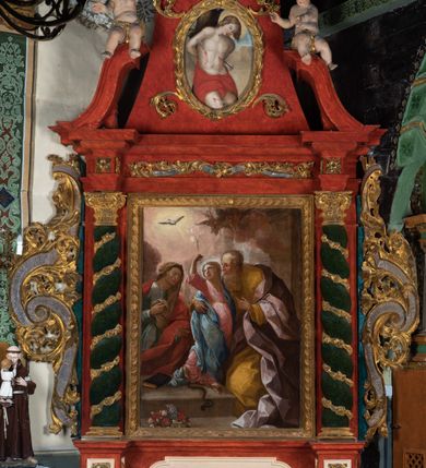 Zdjęcie nr 2: Ołtarz przyścienny o formach architektonicznych; jednoosiowy, jednokondygnacyjny ze zwieńczeniem, uszaty. Mensa prostopadłościenna; antepedium malowane z trzema kwiatowymi medalionami mieszczącymi literę J, monogram maryjny oraz literę A na jasnobeżowym tle. Poniżej środkowego medalionu płonące serce przebite krzyżem i kotwicą. W predelli nisza w kształcie poziomego prostokąta z wypukłymi krótszymi bokami, zapewne pierwotnie mieszcząca niezachowany obraz. Nastawa ujęta parą kolumn umieszczonych na wysokich, prostopadłościennych postumentach. Trzony kolumn skręcone, oplecione kwiatowymi girlandami; kompozytowe kapitele złocone. W polu ołtarza złocona, profilowana rama w kształcie pionowego prostokąta mieszcząca obraz z przedstawieniem św. Anny, św. Joachima i Marii. Kolumny dźwigają pełne belkowanie przełamane na osiach podpór oraz odcinki zbudowanego z wolut przyczółka, na których umieszczono pełnoplastyczne figurki aniołów. W partii fryzu złocony ornament akantowy przepleciony srebrzoną wstęgą  oraz rozetki. Zwieńczenie w kształcie trapezu równoramiennego o wklęsłych bokach, zamknięte od góry gzymsem w formie łuku nadwieszonego. W polu owalna, złocona rama w kształcie wieńca laurowego mieszcząca obraz przedstawiający św. Sebastiana, ponad którym akantowy kartusz owalny z inskrypcją „IN HONOREM S(ANCTI) JOACHIM ANNO DOMINI 1518”. Nastawa ujęta ażurowymi, złoconymi i srebrzonymi uszami utworzonymi z suchego akantu oraz karbowanej wstęgi. Struktura ołtarza „marmoryzowana” w odcieniach czerwieni; dekoracja snycerska srebrzona i złocona, trzony kolumn czarne.



