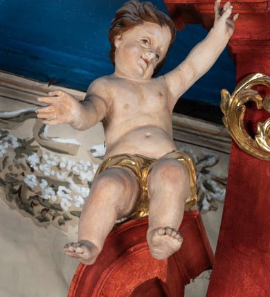 Zdjęcie nr 7: Ołtarz przyścienny o formach architektonicznych; jednoosiowy, jednokondygnacyjny ze zwieńczeniem, uszaty. Mensa prostopadłościenna; antepedium malowane z trzema kwiatowymi medalionami mieszczącymi literę J, monogram maryjny oraz literę A na jasnobeżowym tle. Poniżej środkowego medalionu płonące serce przebite krzyżem i kotwicą. W predelli nisza w kształcie poziomego prostokąta z wypukłymi krótszymi bokami, zapewne pierwotnie mieszcząca niezachowany obraz. Nastawa ujęta parą kolumn umieszczonych na wysokich, prostopadłościennych postumentach. Trzony kolumn skręcone, oplecione kwiatowymi girlandami; kompozytowe kapitele złocone. W polu ołtarza złocona, profilowana rama w kształcie pionowego prostokąta mieszcząca obraz z przedstawieniem św. Anny, św. Joachima i Marii. Kolumny dźwigają pełne belkowanie przełamane na osiach podpór oraz odcinki zbudowanego z wolut przyczółka, na których umieszczono pełnoplastyczne figurki aniołów. W partii fryzu złocony ornament akantowy przepleciony srebrzoną wstęgą  oraz rozetki. Zwieńczenie w kształcie trapezu równoramiennego o wklęsłych bokach, zamknięte od góry gzymsem w formie łuku nadwieszonego. W polu owalna, złocona rama w kształcie wieńca laurowego mieszcząca obraz przedstawiający św. Sebastiana, ponad którym akantowy kartusz owalny z inskrypcją „IN HONOREM S(ANCTI) JOACHIM ANNO DOMINI 1518”. Nastawa ujęta ażurowymi, złoconymi i srebrzonymi uszami utworzonymi z suchego akantu oraz karbowanej wstęgi. Struktura ołtarza „marmoryzowana” w odcieniach czerwieni; dekoracja snycerska srebrzona i złocona, trzony kolumn czarne.



