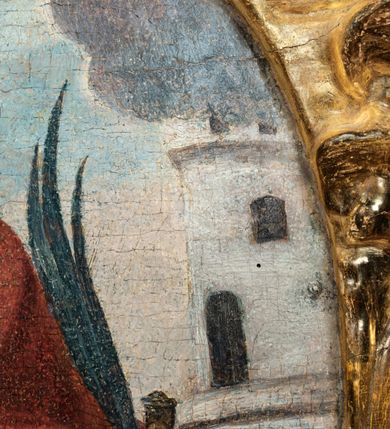 Zdjęcie nr 7: Obraz w kształcie stojącego owalu, ujęty drewnianą, złoconą ramą utworzoną z płomienistego akantu. W centrum kompozycji  św. Barbara przedstawiona frontalnie, w pozycji siedzącej z głową zwróconą w trzech czwartych w prawo. Święta ukazana jako młoda kobieta o okrągłej twarzy i długich, ciemnych włosach zaczesanych do tyłu. Karnacja postaci jasna, z delikatnie zaróżowionymi policzkami. Duże, ciemne oczy o kształcie migdałów podkreślają łukowato wygięte brwi. Nos prosty, mały. Usta niewielkie, rozchylone w delikatnym uśmiechu. W prawym uchu postaci niewielki kolczyk. Na głowie upięty biały welon dekorowany sznurami pereł; wokół niej świetlisty nimb. Święta Barbara ubrana jest w żółtą szatę spodnią, na której znajduje się błękitna suknia oraz luźno przerzucony przez lewe ramię obszerny czerwony płaszcz. W prawej dłoni postać trzyma złoty kielich z hostią, na której widnieje monogram IHS oraz krzyż. Hostię otacza gloria promienista. W lewej dłoni święta trzyma miecz skierowany ostrzem ku dołowi oraz palmę męczeństwa. Na drugim planie widoczne dwie wieże. Z lewej nieco wyższa z dwoma półkoliście zamkniętymi oknami oraz balkonem; z prawej niższa, również z dwoma oknami, zwieńczona krenelażem. W tle błękitne niebo z zaznaczonymi jasnoszarymi obłokami.

