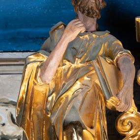 Zdjęcie nr 1: Rzeźba pełnoplastyczna ustawiona na niewielkim prostopadłościennym postumencie zwieńczonym złoconym gzymsem. Święty Paweł (?) ukazany frontalnie w pozycji stojącej, w wyraźnym kontrapoście z lewą noga lekko ugiętą w kolanie, wysuniętą do przodu i wspartą na skale. Głowa zwrócona w trzech czwartych w prawo w kierunku osi ołtarza. Włosy krótkie, kędzierzawe, przerzedzone nad czołem; zarost krótki, falowany. Twarz pociągła o wypukłym czole, oczy głęboko osadzone, nos prosty. Prawa ręka zgięta w łokciu i uniesiona do góry. Dłoń zwinięta do środka w geście trzymania – zapewne w tym miejscu znajdował się niezachowany atrybut. Lewa ręka opuszczona w dół, podtrzymująca dużą księgę. Święty ubrany w długą, obficie fałdowaną, przewiązaną w pasie złotą szatę z sięgającymi łokci rękawami oraz obszerny, bogato fałdowany płaszcz. Spod szaty wystają bose stopy. Partie karnacji polichromowane, szaty i atrybut złocone.


