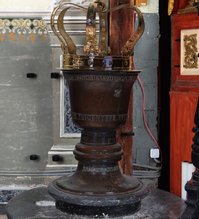 Zdjęcie nr 1: Odlana z brązu chrzcielnica ma kształt przysadzistego kielicha z pokrywą w kształcie królewskiej korony. 
Chrzcielnica ustawiona jest na dwustopniowym, marmurowym postumencie zbudowanym z dwóch koncentrycznych kół. Stopa chrzcielnicy o obrysie okrągłym z profilowanym, schodkowym cokołem i gładkim płaszczem. Trzon masywny, gładki, z nodusem o kształcie kolistym, spłaszczonym, potrójnie, półokrągło profilowanym. Czara chrzcielnicy z płaszczem gładkim, lekko się rozszerzającym oraz nieznacznie wywiniętym, profilowanym brzegiem. W górnej części czary otok z napisem wykonanym majuskułą renesansową, stanowiącym wers Psalmu 115 „NON NOBIS DOMINE NON NOBIS SED NOMINI TVO DA GLORIAM”. W dolnej części czary otok z podobnie wykonanym napisem, stanowiącym wers z Psalmu  117 „LAVDAT DOMINUM OMENS GENTES LAVDATE EVM OMNES POPVLI”. Na płaszczu czary, pomiędzy inskrypcjami, wizerunek Chrystusa Ukrzyżowanego ze stojącymi po bokach krzyża postaciami matki Boskiej i Marii Magdaleny. Po przeciwnej stronie czary herb Kroje. Na trzonie chrzcielnicy, między nodusem a czarą data „1533”. W górnej części tulei, pod nodusem napis  „ANNO DOMINI PRO PAULO”. Na brzegu stopy niezidentyfikowany herb, prawdopodobnie znak odlewni.
