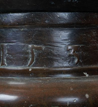 Zdjęcie nr 3: Wykonana z miedzi pokrywa chrzcielnicy  ma kształt korony królewskiej. Obręcz i  kabłąki korony wykonane z płaskownika z profilowanymi brzegami, zdobione  trybowanymi, półokrągłymi guzami. U nasady kabłąków kwiaty o czterech płatkach. Korona zwieńczona jabłkiem z krzyżem maltańskim. Na obręczy korony jest inskrypcja „X(iądz) Benedykt Parszywka Karmelita Bosy z Czerny Ofiarowal R(oku) 1852”. 