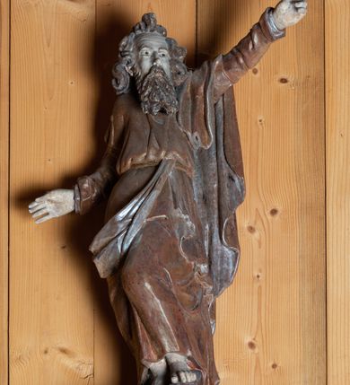 Zdjęcie nr 1: Rzeźba pełnoplastyczna, ścięta z tyłu, ustawiona na niewielkim ośmiobocznym postumencie. Święty ukazany  w całej postaci, frontalnie w postawie stojącej, w wyraźnym kontrapoście. Lewa noga postaci zgięta w kolanie, wysunięta do przodu, bosa stopa wsparta na postumencie. Prawa ręka świętego lekko ugięta w łokciu i odwiedziona w lewo, ku dołowi. Lewa wyprostowana, wzniesiona ku górze; dłoń z palcem wskazującym skierowanym na wprost. Głowa św. Andrzeja  skierowana nieznacznie w lewo. Twarz szczupła, podłużna z wysokim czołem, niewielkimi oczami oraz krótkim, prostym nosem. Dłuższe włosy skręcone w mięsistych puklach, na czubku głowy tworzą szpic. Broda sięgająca piersi, kędzierzawa. Włosy i zarost szarobrązowe. Święty jest ubrany w długą, złotą szatę przewiązaną w pasie. Na nią narzucony jest złoty płaszcz ze srebrną podszewką przewieszony swobodnie przez lewe ramię.