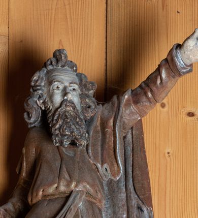 Zdjęcie nr 2: Rzeźba pełnoplastyczna, ścięta z tyłu, ustawiona na niewielkim ośmiobocznym postumencie. Święty ukazany  w całej postaci, frontalnie w postawie stojącej, w wyraźnym kontrapoście. Lewa noga postaci zgięta w kolanie, wysunięta do przodu, bosa stopa wsparta na postumencie. Prawa ręka świętego lekko ugięta w łokciu i odwiedziona w lewo, ku dołowi. Lewa wyprostowana, wzniesiona ku górze; dłoń z palcem wskazującym skierowanym na wprost. Głowa św. Andrzeja  skierowana nieznacznie w lewo. Twarz szczupła, podłużna z wysokim czołem, niewielkimi oczami oraz krótkim, prostym nosem. Dłuższe włosy skręcone w mięsistych puklach, na czubku głowy tworzą szpic. Broda sięgająca piersi, kędzierzawa. Włosy i zarost szarobrązowe. Święty jest ubrany w długą, złotą szatę przewiązaną w pasie. Na nią narzucony jest złoty płaszcz ze srebrną podszewką przewieszony swobodnie przez lewe ramię.