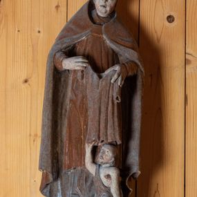 Zdjęcie nr 1: Rzeźba pełnoplastyczna, ścięta z tyłu, ustawiona na niewielkiej podstawie o nieregularnym kształcie. Biskup ukazany w całej postaci, frontalnie w postawie stojącej. U jego stóp po prawej stronie kompozycji przedstawiona w pomniejszonej skali postać klęczącego żebraka. Głowa św. Marcina lekko pochylona do dołu. Święty w ugiętych łokciach rękach trzyma przed sobą szatę, którą zamierza nałożyć klęczącemu żebrakowi. Twarz biskupa podłużna o wyraźnie zaznaczonym, lekko zaokrąglonym podbródku, krótkim nosie oraz lekko rozchylonych ustach; pozbawiona zarostu. Biskup ubrany jest w długą albę, złoconą dalmatykę sięgającą za kolana oraz złoty, podbity srebrną tkaniną płaszcz sięgający ziemi. Na głowie świętego przedstawiona infuła biskupia. Na dłoniach rękawiczki. Spod alby widoczna prawa stopa w obuwiu o zaokrąglonych noskach. Żebrak przedstawiony jako brodaty mężczyzna o okrągłej, pozbawionej włosów głowie. Swój wzrok kieruje ku górze, w kierunku św. Marcina. Prawą, uniesioną do góry ręką chwyta brzeg szaty nakładanej mu przez świętego. Lewa ręka, wsparta na kuli, opuszczona wzdłuż tułowia. Przez prawe ramię  postaci przewieszona srebrna szata, luźno okrywająca ciało. Tors odsłonięty.

