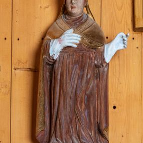 Zdjęcie nr 1: Rzeźba pełnoplastyczna, ścięta z tyłu, ustawiona na niewielkim postumencie. Święty ukazany w całej postaci, stojący frontalnie, w delikatnym kontrapoście, z lewą nogą lekko ugiętą w kolanie. Ręce postaci zgięte w łokciach. Prawa dłoń świętego spoczywa na piersi, lewa odsunięta jest w bok od ciała. Twarz papieża okrągła, pozbawiona zarostu, z pełnymi policzkami oraz podwójnym podbródkiem. Oczy duże migdałowate, wzrok skierowany przed siebie. Brwi wyraźne, łukowate, nos długi, prosty, usta niewielkie. Na głowie świętego umieszczona złota tiara. Papież ubrany jest w długą, czerwoną szatę oraz złotą, spiętą pod szyją kapę, której brzeg dekorowany jest wzorem z rombów. Na rękach postaci białe, sięgające łokci rękawice dekorowane czerwonymi krzyżami. Spod szaty widoczne czubki butów.