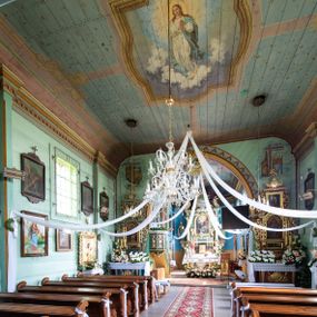 Zdjęcie nr 1: Polichromia w postaci kompozycji figuralnych zajmuje powierzchnię stropu korpusu nawowego i prezbiterium. Pośrodku stropu nawy znajduje się pole w kształcie stojącego prostokąta, którego boki mają formę półkolistych i odcinkowych łuków nadwieszonych, ujęte jest iluzjonistyczną, polichromowaną profilowaną ramą z motywem plecionki. W środku wizerunek Matki Boskiej Niepokalanie Poczętej. Zwrócona w trzech czwartych w prawo Maria stoi na obłokach z sierpem księżyca pod nogami. Sylwetka w S-kształtnym układzie. Owalną twarz charakteryzują delikatne rysy i półprzymknięte oczy. Długie, falowane włosy opadają na ramiona i plecy. Maria ma na sobie białą suknię i błękitny, rozwiany płaszcz przerzucony przez lewe ramię. Ręce złożone w geście modlitwy. Głowę ujmuje świetlisty nimb. Pozostała powierzchnia stropu podzielona różowymi pasami na 4 pola pomalowane w kolorze błękitnym i pokryte złotymi gwiazdami.
Polichromia stopu prezbiterium w postaci pól wydzielonych na rzucie dużego, równoramiennego krzyża o rozszerzających się ramionach, linia obramienia w formie stylizowanej wici roślinnej z kwiatami. Pole środkowe w kształcie koła. W każde z ramion wpisana sylwetka siedzącego na obłoku anioła w układzie frontalnym. Charakteryzują ich twarze o młodzieńczych rysach, długie, falowane włosy opadające na ramiona. Białe suknie obszyte złotymi galonami oraz osłaniające nogi płaszcze w kolorach czerwonym, zielonym i żółtym. Głowy okalają promieniste nimby. Na plecach wielobarwne skrzydła a w dłoniach rozłożone banderole z napisami – anioł od strony północnej „NAZAREŃSKI SLICZNY KOŚCIELE”, południowej „PRZYJDŹ DUCHU STWORZYCIELU”, wschodniej „ŚWIĘTY ŚWIĘTY ŚWIĘTY”, zachodniej „BOŻE OJCZE TWOJE DZIECI”. Pomiędzy polami z aniołami rodzaj 4 katuszy o szafirowych tłach z motywami: lilii z wieńcem różanym, gorejącego serca z kotwicą, skrzyżowane gałązki palmowe koroną nad nimi i gwiazdą u dołu oraz skrzyżowane klucze z monogramem imienia Jezus i 3 gwoźdźmi. Całość na błękitnym tle pokrytym złotymi gwiazdami ujęta bordiurą w formie stylizowanej wici roślinnej z naprzemiennie żółtymi i czerwonymi kwiatami. Na zakończeniu prezbiterium motyw polichromowanej konchy zdobionej gałązkami różanymi i uskrzydlonymi główkami aniołków naprzemiennie z dużymi kwiatami białych irysów. Kolorystyka polichromii zróżnicowana o żywej, nasyconej gamie.   
