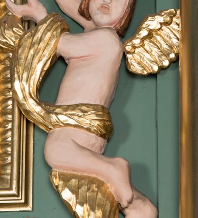 Zdjęcie nr 16: Ołtarz architektoniczny, jednokondygnacyjny, jednoosiowy ze zwieńczeniem. Ołtarz prostopadłościenny, z drewnianą mensą. Antepedium ujęte szerokim obramieniem, pośrodku w polu w kształcie koła złocony monogram imienia Jezus. Retabulum osadzone na zryzalitowanym po bokach cokole, ujętym parą wolutowych impostów. Część środkowa flankowana parą kolumn wspierających niepełne, wyłamujące się ponad nimi, przerwane w partii fryzu belkowanie. Zwieńczenie ujęte parą spływów wolutowych, zamknięte fragmentem gzymsu w postaci półkolistego łuku nadwieszonego, po bokach przerwany, półkolisty przyczółek. Pola cokołu zdobione motywami wici roślinnej. W dolnej części pola środkowego nastawy kwietna girlanda, wyżej, po bokach para aniołków, w górnej partii pośrodku gzymsu kartusz z napisem „OTO BARANEK BOŻY” z podwieszeniem w formie podwiązanej w narożach polach kotary. W partiach fryzu rozety. W zwieńczeniu motyw płaskorzeźbionej Baranka Paschalnego ujętego promienistą glorią. Dolną część spływów wolutowych zdobią liście akantu. Szczyt w formie krzyża osadzonego na ażurowej podstawie w postaci wici akantowej, ujęty parą płomienistych wazonów. Na przerwanym przyczółku para figur siedzących aniołków. Pole części środkowej retabulum w kształcie zbliżonym do kwadratu, zamkniętym półkoliście, ujętym rzeźbioną, złoconą ramą. W środku obraz „Trójcy Świętej”. Po bokach retabulum para rzeźb, po lewej św. Jakub, po prawej św. Józef. Struktura polichromowana w kolorze zielonym i niebieskim, detal architektoniczny złocony i srebrzony.   