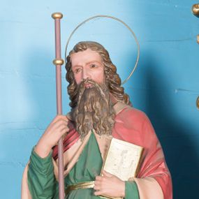 Zdjęcie nr 1: Całopostaciowa, drążona z tyłu figura św. Jakuba zwróconego na wprost, stojącego w wyraźnym kontrapoście na niewysokiej ośmiobocznej podstawie. Pociągłą twarz charakteryzują  delikatne rysy oraz długi, brązowy zarost. Długie, kręcone włosy opadają na plecy. Głowę okala wąska aureola. Święty ubrany jest w zieloną, przewiązaną złoconym pasem suknię i spięty pod szyją, czerwony płaszcz z jasnoróżowym podszyciem. W prawej dłoni trzyma laskę na długim drzewcu ozdobionym parą złoconych nodusów w górnej partii, w lewej zaś zamkniętą księgę w złoconej oprawie. 