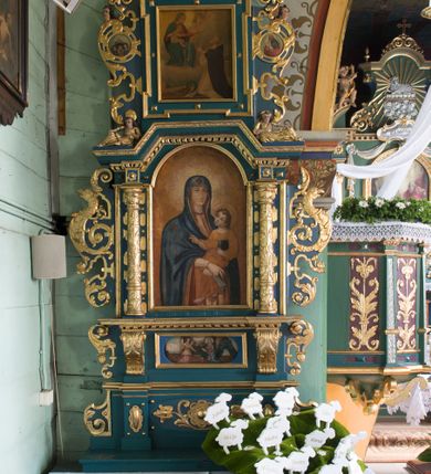 Zdjęcie nr 2: Ołtarz architektoniczny, jednokondygnacyjny, jednoosiowy ze zwieńczeniem. Ołtarz prostopadłościenny, o przednich narożach ujętych pilastrami hermowymi, z drewniana mensą. Antepedium w formie prostokątnej płyciny z płaskorzeźbionym medalionem z monogramem maryjnym okolonym drobnymi promieniami i ujętym liśćmi i kwiatami narcyza. Retabulum osadzone na niewysokim cokole, lekko zryzalitowanym po bokach. Wyżej predella ujęta parą konsoli wolutowych wspierających wyłamujący się ponad nimi gzyms. Cokół wraz z predellą flankowany parą uszaków w formie spływów wolutowych. Część środkowa ujęta parą kolumn o trzonach zdobionych motywem kandelabru, wspierających fryz wyłamujący się ponad nimi oraz gzyms przybierające postać trójboczną. Zwieńczenie w kształcie kwadratu zamkniętego odcinkiem gzymsu o lekko zryzalitowanych bokach. Predellę, część środkową i zwieńczenie ujmują pary ujmują pary uszaków o fantazyjnych wykrojach, zdobione ornamentem okuciowym i wicią roślinną. Uszaki zwieńczenia dodatkowo zdobione parą główek anielskich i medalionów ze św. Józefem po prawej stronie i św. Zofią po lewej. Na bokach gzymsu para figur siedzących aniołów. Szczyt w postaci ujętego parą wolut i zwieńczonego krzyżem kartusza z okrągłym  medalionem z monogramem maryjnym. w predelli obraz w kształcie leżącego prostokąta ze sceną Zwiastowania. Pole środkowe retabulum, ujęte motywami kaboszonów, ma kształt stojącego prostokąta zamkniętego półkolistym łukiem nadwieszonym, w środku obraz Madonny z Dzieciątkiem. W zwieńczeniu obraz w kształcie stojącego prostokąta, ujęty szeroką ramą z uszakami w narożach, zdobioną ornamentem. W środku wizerunek Matki Boskiej Różańcowej ze św. Dominikiem. Struktura polichromowana w odcieniach koloru niebieskiego, detal architektoniczny i ornamentyka złocone i srebrzone.      