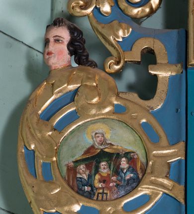 Zdjęcie nr 8: Ołtarz architektoniczny, jednokondygnacyjny, jednoosiowy ze zwieńczeniem. Ołtarz prostopadłościenny, o przednich narożach ujętych pilastrami hermowymi, z drewniana mensą. Antepedium w formie prostokątnej płyciny z płaskorzeźbionym medalionem z monogramem maryjnym okolonym drobnymi promieniami i ujętym liśćmi i kwiatami narcyza. Retabulum osadzone na niewysokim cokole, lekko zryzalitowanym po bokach. Wyżej predella ujęta parą konsoli wolutowych wspierających wyłamujący się ponad nimi gzyms. Cokół wraz z predellą flankowany parą uszaków w formie spływów wolutowych. Część środkowa ujęta parą kolumn o trzonach zdobionych motywem kandelabru, wspierających fryz wyłamujący się ponad nimi oraz gzyms przybierające postać trójboczną. Zwieńczenie w kształcie kwadratu zamkniętego odcinkiem gzymsu o lekko zryzalitowanych bokach. Predellę, część środkową i zwieńczenie ujmują pary ujmują pary uszaków o fantazyjnych wykrojach, zdobione ornamentem okuciowym i wicią roślinną. Uszaki zwieńczenia dodatkowo zdobione parą główek anielskich i medalionów ze św. Józefem po prawej stronie i św. Zofią po lewej. Na bokach gzymsu para figur siedzących aniołów. Szczyt w postaci ujętego parą wolut i zwieńczonego krzyżem kartusza z okrągłym  medalionem z monogramem maryjnym. w predelli obraz w kształcie leżącego prostokąta ze sceną Zwiastowania. Pole środkowe retabulum, ujęte motywami kaboszonów, ma kształt stojącego prostokąta zamkniętego półkolistym łukiem nadwieszonym, w środku obraz Madonny z Dzieciątkiem. W zwieńczeniu obraz w kształcie stojącego prostokąta, ujęty szeroką ramą z uszakami w narożach, zdobioną ornamentem. W środku wizerunek Matki Boskiej Różańcowej ze św. Dominikiem. Struktura polichromowana w odcieniach koloru niebieskiego, detal architektoniczny i ornamentyka złocone i srebrzone.      