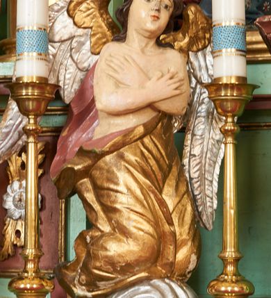 Zdjęcie nr 17: Nastawa ołtarzowa architektoniczna, jednoosiowa, dwukondygnacyjna na cokole z wyodrębnionymi dwoma prostopadłościanami. Ołtarz prostopadłościenny, zwężający się ku dołowi, mensa drewniana. Antepedium marmoryzowane z iluzjonistycznie malowanymi płycinami. Tabernakulum w formie drewnianej skrzynki, półkoliście wybrzuszone od frontu, zakończone profilowanym gzymsem. Drzwiczki o kształcie stojącego prostokąta zamknięte ostrołukiem z malowanym gorejącym sercem, flankowane płaskorzeźbioną winną latoroślą. Tabernakulum ujęte dwiema figurami klęczących na obłokach aniołów. Pierwsza kondygnacja flankowana dwiema parami pilastrów, zewnętrzna o kanelowanych trzonach. Przed wewnętrzną parą stoją dwie kolumny o kapitelach kompozytowych, przed zewnętrzną ustawione są figury św. Stefana i św. Władysława. Podpory dźwigają pełne belkowanie z silnie wysuniętym gzymsem, wyłamane pod kątem w partii kolumn, przerwane pośrodku. W polu centralnym nisza w formie stojącego prostokąta o ściętych górnych narożach ujęta profilowaną ramą, z grupą rzeźbiarską Matki Boskiej z Lourdes i Bernadetą Soubirous. W górnej partii nisza dekorowana zwisami owocowo-kwiatowymi. Pierwsza kondygnacja ujęta uszami utworzonymi z akantu i karbowanej wstęgi. Druga kondygnacja flankowana parą kolumn oraz parą figur św. Marka i św. Mateusza na cokołach. Podpory dźwigają pełne belkowanie z silnie wysuniętym gzymsem, wyłamane na ich osi, przerwane nad polem środkowym. Na belkowaniu dwie figurki aniołków, pośrodku na wsporniku figura Chrystusa w glorii, pośród obłoków. W polu obraz Chrystusa Dobrego Pasterza w formie leżącego prostokąta o ściętych narożach, w ramie. Druga kondygnacja ujęta uszami utworzonymi z akantu. Struktura polichromowana w kolorze jasnozielonym, kolumny, ornamentyka i profile złocone, detal srebrzony. 

