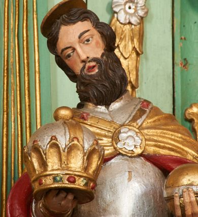 Zdjęcie nr 14: Nastawa ołtarzowa architektoniczna, jednoosiowa, dwukondygnacyjna na cokole z wyodrębnionymi dwoma prostopadłościanami. Ołtarz prostopadłościenny, zwężający się ku dołowi, mensa drewniana. Antepedium marmoryzowane z iluzjonistycznie malowanymi płycinami. Tabernakulum w formie drewnianej skrzynki, półkoliście wybrzuszone od frontu, zakończone profilowanym gzymsem. Drzwiczki o kształcie stojącego prostokąta zamknięte ostrołukiem z malowanym gorejącym sercem, flankowane płaskorzeźbioną winną latoroślą. Tabernakulum ujęte dwiema figurami klęczących na obłokach aniołów. Pierwsza kondygnacja flankowana dwiema parami pilastrów, zewnętrzna o kanelowanych trzonach. Przed wewnętrzną parą stoją dwie kolumny o kapitelach kompozytowych, przed zewnętrzną ustawione są figury św. Stefana i św. Władysława. Podpory dźwigają pełne belkowanie z silnie wysuniętym gzymsem, wyłamane pod kątem w partii kolumn, przerwane pośrodku. W polu centralnym nisza w formie stojącego prostokąta o ściętych górnych narożach ujęta profilowaną ramą, z grupą rzeźbiarską Matki Boskiej z Lourdes i Bernadetą Soubirous. W górnej partii nisza dekorowana zwisami owocowo-kwiatowymi. Pierwsza kondygnacja ujęta uszami utworzonymi z akantu i karbowanej wstęgi. Druga kondygnacja flankowana parą kolumn oraz parą figur św. Marka i św. Mateusza na cokołach. Podpory dźwigają pełne belkowanie z silnie wysuniętym gzymsem, wyłamane na ich osi, przerwane nad polem środkowym. Na belkowaniu dwie figurki aniołków, pośrodku na wsporniku figura Chrystusa w glorii, pośród obłoków. W polu obraz Chrystusa Dobrego Pasterza w formie leżącego prostokąta o ściętych narożach, w ramie. Druga kondygnacja ujęta uszami utworzonymi z akantu. Struktura polichromowana w kolorze jasnozielonym, kolumny, ornamentyka i profile złocone, detal srebrzony. 

