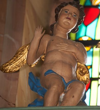 Zdjęcie nr 15: Nastawa ołtarzowa architektoniczna, jednoosiowa, dwukondygnacyjna na cokole z wyodrębnionymi dwoma prostopadłościanami. Ołtarz prostopadłościenny, zwężający się ku dołowi, mensa drewniana. Antepedium marmoryzowane z iluzjonistycznie malowanymi płycinami. Tabernakulum w formie drewnianej skrzynki, półkoliście wybrzuszone od frontu, zakończone profilowanym gzymsem. Drzwiczki o kształcie stojącego prostokąta zamknięte ostrołukiem z malowanym gorejącym sercem, flankowane płaskorzeźbioną winną latoroślą. Tabernakulum ujęte dwiema figurami klęczących na obłokach aniołów. Pierwsza kondygnacja flankowana dwiema parami pilastrów, zewnętrzna o kanelowanych trzonach. Przed wewnętrzną parą stoją dwie kolumny o kapitelach kompozytowych, przed zewnętrzną ustawione są figury św. Stefana i św. Władysława. Podpory dźwigają pełne belkowanie z silnie wysuniętym gzymsem, wyłamane pod kątem w partii kolumn, przerwane pośrodku. W polu centralnym nisza w formie stojącego prostokąta o ściętych górnych narożach ujęta profilowaną ramą, z grupą rzeźbiarską Matki Boskiej z Lourdes i Bernadetą Soubirous. W górnej partii nisza dekorowana zwisami owocowo-kwiatowymi. Pierwsza kondygnacja ujęta uszami utworzonymi z akantu i karbowanej wstęgi. Druga kondygnacja flankowana parą kolumn oraz parą figur św. Marka i św. Mateusza na cokołach. Podpory dźwigają pełne belkowanie z silnie wysuniętym gzymsem, wyłamane na ich osi, przerwane nad polem środkowym. Na belkowaniu dwie figurki aniołków, pośrodku na wsporniku figura Chrystusa w glorii, pośród obłoków. W polu obraz Chrystusa Dobrego Pasterza w formie leżącego prostokąta o ściętych narożach, w ramie. Druga kondygnacja ujęta uszami utworzonymi z akantu. Struktura polichromowana w kolorze jasnozielonym, kolumny, ornamentyka i profile złocone, detal srebrzony. 

