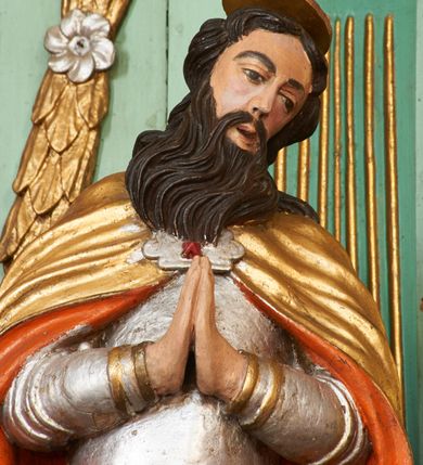 Zdjęcie nr 12: Nastawa ołtarzowa architektoniczna, jednoosiowa, dwukondygnacyjna na cokole z wyodrębnionymi dwoma prostopadłościanami. Ołtarz prostopadłościenny, zwężający się ku dołowi, mensa drewniana. Antepedium marmoryzowane z iluzjonistycznie malowanymi płycinami. Tabernakulum w formie drewnianej skrzynki, półkoliście wybrzuszone od frontu, zakończone profilowanym gzymsem. Drzwiczki o kształcie stojącego prostokąta zamknięte ostrołukiem z malowanym gorejącym sercem, flankowane płaskorzeźbioną winną latoroślą. Tabernakulum ujęte dwiema figurami klęczących na obłokach aniołów. Pierwsza kondygnacja flankowana dwiema parami pilastrów, zewnętrzna o kanelowanych trzonach. Przed wewnętrzną parą stoją dwie kolumny o kapitelach kompozytowych, przed zewnętrzną ustawione są figury św. Stefana i św. Władysława. Podpory dźwigają pełne belkowanie z silnie wysuniętym gzymsem, wyłamane pod kątem w partii kolumn, przerwane pośrodku. W polu centralnym nisza w formie stojącego prostokąta o ściętych górnych narożach ujęta profilowaną ramą, z grupą rzeźbiarską Matki Boskiej z Lourdes i Bernadetą Soubirous. W górnej partii nisza dekorowana zwisami owocowo-kwiatowymi. Pierwsza kondygnacja ujęta uszami utworzonymi z akantu i karbowanej wstęgi. Druga kondygnacja flankowana parą kolumn oraz parą figur św. Marka i św. Mateusza na cokołach. Podpory dźwigają pełne belkowanie z silnie wysuniętym gzymsem, wyłamane na ich osi, przerwane nad polem środkowym. Na belkowaniu dwie figurki aniołków, pośrodku na wsporniku figura Chrystusa w glorii, pośród obłoków. W polu obraz Chrystusa Dobrego Pasterza w formie leżącego prostokąta o ściętych narożach, w ramie. Druga kondygnacja ujęta uszami utworzonymi z akantu. Struktura polichromowana w kolorze jasnozielonym, kolumny, ornamentyka i profile złocone, detal srebrzony. 

