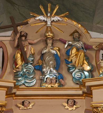 Zdjęcie nr 4: Nastawa ołtarzowa architektoniczna, dwukondygnacyjna ze zwieńczeniem, obie kondygnacje trójosiowe. Ołtarz murowany, prostopadłościenny, mensa z kamiennym portatylem. Antepedium dekorowane malowaną iluzjonistycznie prostokątną płyciną z wypukłymi krótszymi bokami. Na ołtarzu tabernakulum w formie drewnianej skrzynki ujętej kolumienkami podtrzymującymi gzyms. Do niego wbudowana drewniana skrzynka obita metalową blachą, z drzwiczkami w kształcie stojącego prostokąta, ujętego ramą, z wizerunkiem krzyża, winnego grona, kłosów zbóż i kielicha z hostią w polu. Całość flankowana uszami utworzonymi z cęg i kratki. Na tabernakulum tron wystawienia przyjmujący postać glorii promienistej, z parą aniołów unoszącą nad nią koronę zamkniętą. Tron flankowany dwoma klęczącymi aniołkami trzymającymi lichtarze ze świecami. Pierwsza kondygnacja na dwustrefowym cokole, w górnej partii z wyodrębnionymi prostopadłościanami, dekorowanymi płycinami z ornamentem roślinnym. Osie wydzielone czterema kolumnami o kapitelach kompozytowych, dźwigających pełne belkowanie z silnie wysuniętym gzymsem, wyłamane na ich osi oraz ustawione pod kątem na zewnątrz. Fryz dekorowany medalionem z monogramem IHS, uskrzydlonymi główkami anielskimi i ornamentem roślinnym. W polu środkowym wnęka w formie stojącego prostokąta, ujęta profilowaną ramą, z obrazem św. Jakuba. Wnęka flankowana figurami św. Katarzyny Aleksandryjskiej i św. Barbary ustawionymi na cokołach. Na osiach bocznych rzeźby św. Jana Chrzciciela i św. Andrzeja na cokołach. Pierwsza kondygnacja flankowana uszami utworzonymi z wici roślinnej i kratki. Druga kondygnacja na cokole z wyodrębnionymi prostopadłościanami, dekorowanymi płycinami z ornamentem roślinnym. Osie wydzielone czterema kolumnami o kapitelach kompozytowych, dźwigającymi pełne belkowanie, wyłamane na ich osi. Wewnętrzna para zwrócona pod kątem do środka, para skrajna na zewnątrz. Fryz dekorowany uskrzydlonymi główkami anielskimi. W polu obraz św. Józefa z Dzieciątkiem w formie stojącego prostokąta zamkniętego łukiem odcinkowym, ujęty profilowaną ramą. Na osiach bocznych ustawione figury niezidentyfikowanej świętej i św. Jadwigi (?). Na skraju belkowania pierwszej kondygnacji umiejscowione rzeźby Marii i św. Jana. Druga kondygnacja flankowana uszami utworzonymi z wici roślinnej. Zwieńczenie w kształcie zbliżonym do leżącego prostokąta, o wklęsłych bokach, zamkniętego łukiem odcinkowym nadwieszonym. W polu grupa rzeźbiarska Koronacji Marii, w której postacie unoszą się na obłokach, nad nimi zaś znajduje się gołębica Ducha Świętego w glorii. Na belkowaniu drugiej kondygnacji ustawione dwa klęczące na obłokach aniołki oraz figury św. Stefana i św. Władysława. Struktura polichromowana w kolorze beżowym, z bladoróżowymi detalami; kolumny malowane na sposób imitujący marmoryzacje w kolorze zielonym; profile i ornamentyka złocone. 

