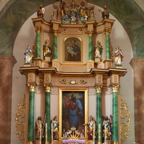 Zdjęcie nr 1: Nastawa ołtarzowa architektoniczna, dwukondygnacyjna ze zwieńczeniem, obie kondygnacje trójosiowe. Ołtarz murowany, prostopadłościenny, mensa z kamiennym portatylem. Antepedium dekorowane malowaną iluzjonistycznie prostokątną płyciną z wypukłymi krótszymi bokami. Na ołtarzu tabernakulum w formie drewnianej skrzynki ujętej kolumienkami podtrzymującymi gzyms. Do niego wbudowana drewniana skrzynka obita metalową blachą, z drzwiczkami w kształcie stojącego prostokąta, ujętego ramą, z wizerunkiem krzyża, winnego grona, kłosów zbóż i kielicha z hostią w polu. Całość flankowana uszami utworzonymi z cęg i kratki. Na tabernakulum tron wystawienia przyjmujący postać glorii promienistej, z parą aniołów unoszącą nad nią koronę zamkniętą. Tron flankowany dwoma klęczącymi aniołkami trzymającymi lichtarze ze świecami. Pierwsza kondygnacja na dwustrefowym cokole, w górnej partii z wyodrębnionymi prostopadłościanami, dekorowanymi płycinami z ornamentem roślinnym. Osie wydzielone czterema kolumnami o kapitelach kompozytowych, dźwigających pełne belkowanie z silnie wysuniętym gzymsem, wyłamane na ich osi oraz ustawione pod kątem na zewnątrz. Fryz dekorowany medalionem z monogramem IHS, uskrzydlonymi główkami anielskimi i ornamentem roślinnym. W polu środkowym wnęka w formie stojącego prostokąta, ujęta profilowaną ramą, z obrazem św. Jakuba. Wnęka flankowana figurami św. Katarzyny Aleksandryjskiej i św. Barbary ustawionymi na cokołach. Na osiach bocznych rzeźby św. Jana Chrzciciela i św. Andrzeja na cokołach. Pierwsza kondygnacja flankowana uszami utworzonymi z wici roślinnej i kratki. Druga kondygnacja na cokole z wyodrębnionymi prostopadłościanami, dekorowanymi płycinami z ornamentem roślinnym. Osie wydzielone czterema kolumnami o kapitelach kompozytowych, dźwigającymi pełne belkowanie, wyłamane na ich osi. Wewnętrzna para zwrócona pod kątem do środka, para skrajna na zewnątrz. Fryz dekorowany uskrzydlonymi główkami anielskimi. W polu obraz św. Józefa z Dzieciątkiem w formie stojącego prostokąta zamkniętego łukiem odcinkowym, ujęty profilowaną ramą. Na osiach bocznych ustawione figury niezidentyfikowanej świętej i św. Jadwigi (?). Na skraju belkowania pierwszej kondygnacji umiejscowione rzeźby Marii i św. Jana. Druga kondygnacja flankowana uszami utworzonymi z wici roślinnej. Zwieńczenie w kształcie zbliżonym do leżącego prostokąta, o wklęsłych bokach, zamkniętego łukiem odcinkowym nadwieszonym. W polu grupa rzeźbiarska Koronacji Marii, w której postacie unoszą się na obłokach, nad nimi zaś znajduje się gołębica Ducha Świętego w glorii. Na belkowaniu drugiej kondygnacji ustawione dwa klęczące na obłokach aniołki oraz figury św. Stefana i św. Władysława. Struktura polichromowana w kolorze beżowym, z bladoróżowymi detalami; kolumny malowane na sposób imitujący marmoryzacje w kolorze zielonym; profile i ornamentyka złocone. 

