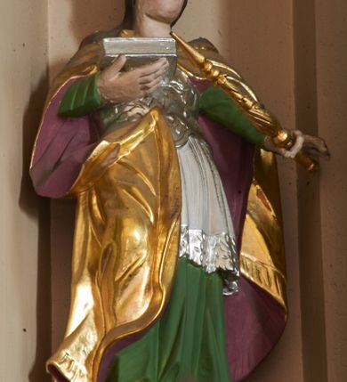 Zdjęcie nr 6: Nastawa ołtarzowa architektoniczna, dwukondygnacyjna ze zwieńczeniem, obie kondygnacje trójosiowe. Ołtarz murowany, prostopadłościenny, mensa z kamiennym portatylem. Antepedium dekorowane malowaną iluzjonistycznie prostokątną płyciną z wypukłymi krótszymi bokami. Na ołtarzu tabernakulum w formie drewnianej skrzynki ujętej kolumienkami podtrzymującymi gzyms. Do niego wbudowana drewniana skrzynka obita metalową blachą, z drzwiczkami w kształcie stojącego prostokąta, ujętego ramą, z wizerunkiem krzyża, winnego grona, kłosów zbóż i kielicha z hostią w polu. Całość flankowana uszami utworzonymi z cęg i kratki. Na tabernakulum tron wystawienia przyjmujący postać glorii promienistej, z parą aniołów unoszącą nad nią koronę zamkniętą. Tron flankowany dwoma klęczącymi aniołkami trzymającymi lichtarze ze świecami. Pierwsza kondygnacja na dwustrefowym cokole, w górnej partii z wyodrębnionymi prostopadłościanami, dekorowanymi płycinami z ornamentem roślinnym. Osie wydzielone czterema kolumnami o kapitelach kompozytowych, dźwigających pełne belkowanie z silnie wysuniętym gzymsem, wyłamane na ich osi oraz ustawione pod kątem na zewnątrz. Fryz dekorowany medalionem z monogramem IHS, uskrzydlonymi główkami anielskimi i ornamentem roślinnym. W polu środkowym wnęka w formie stojącego prostokąta, ujęta profilowaną ramą, z obrazem św. Jakuba. Wnęka flankowana figurami św. Katarzyny Aleksandryjskiej i św. Barbary ustawionymi na cokołach. Na osiach bocznych rzeźby św. Jana Chrzciciela i św. Andrzeja na cokołach. Pierwsza kondygnacja flankowana uszami utworzonymi z wici roślinnej i kratki. Druga kondygnacja na cokole z wyodrębnionymi prostopadłościanami, dekorowanymi płycinami z ornamentem roślinnym. Osie wydzielone czterema kolumnami o kapitelach kompozytowych, dźwigającymi pełne belkowanie, wyłamane na ich osi. Wewnętrzna para zwrócona pod kątem do środka, para skrajna na zewnątrz. Fryz dekorowany uskrzydlonymi główkami anielskimi. W polu obraz św. Józefa z Dzieciątkiem w formie stojącego prostokąta zamkniętego łukiem odcinkowym, ujęty profilowaną ramą. Na osiach bocznych ustawione figury niezidentyfikowanej świętej i św. Jadwigi (?). Na skraju belkowania pierwszej kondygnacji umiejscowione rzeźby Marii i św. Jana. Druga kondygnacja flankowana uszami utworzonymi z wici roślinnej. Zwieńczenie w kształcie zbliżonym do leżącego prostokąta, o wklęsłych bokach, zamkniętego łukiem odcinkowym nadwieszonym. W polu grupa rzeźbiarska Koronacji Marii, w której postacie unoszą się na obłokach, nad nimi zaś znajduje się gołębica Ducha Świętego w glorii. Na belkowaniu drugiej kondygnacji ustawione dwa klęczące na obłokach aniołki oraz figury św. Stefana i św. Władysława. Struktura polichromowana w kolorze beżowym, z bladoróżowymi detalami; kolumny malowane na sposób imitujący marmoryzacje w kolorze zielonym; profile i ornamentyka złocone. 

