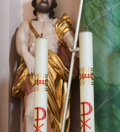 Zdjęcie nr 10: Nastawa ołtarzowa architektoniczna, dwukondygnacyjna ze zwieńczeniem, obie kondygnacje trójosiowe. Ołtarz murowany, prostopadłościenny, mensa z kamiennym portatylem. Antepedium dekorowane malowaną iluzjonistycznie prostokątną płyciną z wypukłymi krótszymi bokami. Na ołtarzu tabernakulum w formie drewnianej skrzynki ujętej kolumienkami podtrzymującymi gzyms. Do niego wbudowana drewniana skrzynka obita metalową blachą, z drzwiczkami w kształcie stojącego prostokąta, ujętego ramą, z wizerunkiem krzyża, winnego grona, kłosów zbóż i kielicha z hostią w polu. Całość flankowana uszami utworzonymi z cęg i kratki. Na tabernakulum tron wystawienia przyjmujący postać glorii promienistej, z parą aniołów unoszącą nad nią koronę zamkniętą. Tron flankowany dwoma klęczącymi aniołkami trzymającymi lichtarze ze świecami. Pierwsza kondygnacja na dwustrefowym cokole, w górnej partii z wyodrębnionymi prostopadłościanami, dekorowanymi płycinami z ornamentem roślinnym. Osie wydzielone czterema kolumnami o kapitelach kompozytowych, dźwigających pełne belkowanie z silnie wysuniętym gzymsem, wyłamane na ich osi oraz ustawione pod kątem na zewnątrz. Fryz dekorowany medalionem z monogramem IHS, uskrzydlonymi główkami anielskimi i ornamentem roślinnym. W polu środkowym wnęka w formie stojącego prostokąta, ujęta profilowaną ramą, z obrazem św. Jakuba. Wnęka flankowana figurami św. Katarzyny Aleksandryjskiej i św. Barbary ustawionymi na cokołach. Na osiach bocznych rzeźby św. Jana Chrzciciela i św. Andrzeja na cokołach. Pierwsza kondygnacja flankowana uszami utworzonymi z wici roślinnej i kratki. Druga kondygnacja na cokole z wyodrębnionymi prostopadłościanami, dekorowanymi płycinami z ornamentem roślinnym. Osie wydzielone czterema kolumnami o kapitelach kompozytowych, dźwigającymi pełne belkowanie, wyłamane na ich osi. Wewnętrzna para zwrócona pod kątem do środka, para skrajna na zewnątrz. Fryz dekorowany uskrzydlonymi główkami anielskimi. W polu obraz św. Józefa z Dzieciątkiem w formie stojącego prostokąta zamkniętego łukiem odcinkowym, ujęty profilowaną ramą. Na osiach bocznych ustawione figury niezidentyfikowanej świętej i św. Jadwigi (?). Na skraju belkowania pierwszej kondygnacji umiejscowione rzeźby Marii i św. Jana. Druga kondygnacja flankowana uszami utworzonymi z wici roślinnej. Zwieńczenie w kształcie zbliżonym do leżącego prostokąta, o wklęsłych bokach, zamkniętego łukiem odcinkowym nadwieszonym. W polu grupa rzeźbiarska Koronacji Marii, w której postacie unoszą się na obłokach, nad nimi zaś znajduje się gołębica Ducha Świętego w glorii. Na belkowaniu drugiej kondygnacji ustawione dwa klęczące na obłokach aniołki oraz figury św. Stefana i św. Władysława. Struktura polichromowana w kolorze beżowym, z bladoróżowymi detalami; kolumny malowane na sposób imitujący marmoryzacje w kolorze zielonym; profile i ornamentyka złocone. 

