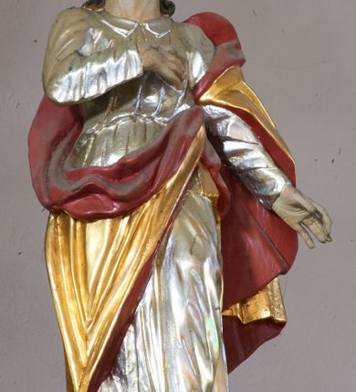 Zdjęcie nr 8: Nastawa ołtarzowa architektoniczna, dwukondygnacyjna ze zwieńczeniem, obie kondygnacje trójosiowe. Ołtarz murowany, prostopadłościenny, mensa z kamiennym portatylem. Antepedium dekorowane malowaną iluzjonistycznie prostokątną płyciną z wypukłymi krótszymi bokami. Na ołtarzu tabernakulum w formie drewnianej skrzynki ujętej kolumienkami podtrzymującymi gzyms. Do niego wbudowana drewniana skrzynka obita metalową blachą, z drzwiczkami w kształcie stojącego prostokąta, ujętego ramą, z wizerunkiem krzyża, winnego grona, kłosów zbóż i kielicha z hostią w polu. Całość flankowana uszami utworzonymi z cęg i kratki. Na tabernakulum tron wystawienia przyjmujący postać glorii promienistej, z parą aniołów unoszącą nad nią koronę zamkniętą. Tron flankowany dwoma klęczącymi aniołkami trzymającymi lichtarze ze świecami. Pierwsza kondygnacja na dwustrefowym cokole, w górnej partii z wyodrębnionymi prostopadłościanami, dekorowanymi płycinami z ornamentem roślinnym. Osie wydzielone czterema kolumnami o kapitelach kompozytowych, dźwigających pełne belkowanie z silnie wysuniętym gzymsem, wyłamane na ich osi oraz ustawione pod kątem na zewnątrz. Fryz dekorowany medalionem z monogramem IHS, uskrzydlonymi główkami anielskimi i ornamentem roślinnym. W polu środkowym wnęka w formie stojącego prostokąta, ujęta profilowaną ramą, z obrazem św. Jakuba. Wnęka flankowana figurami św. Katarzyny Aleksandryjskiej i św. Barbary ustawionymi na cokołach. Na osiach bocznych rzeźby św. Jana Chrzciciela i św. Andrzeja na cokołach. Pierwsza kondygnacja flankowana uszami utworzonymi z wici roślinnej i kratki. Druga kondygnacja na cokole z wyodrębnionymi prostopadłościanami, dekorowanymi płycinami z ornamentem roślinnym. Osie wydzielone czterema kolumnami o kapitelach kompozytowych, dźwigającymi pełne belkowanie, wyłamane na ich osi. Wewnętrzna para zwrócona pod kątem do środka, para skrajna na zewnątrz. Fryz dekorowany uskrzydlonymi główkami anielskimi. W polu obraz św. Józefa z Dzieciątkiem w formie stojącego prostokąta zamkniętego łukiem odcinkowym, ujęty profilowaną ramą. Na osiach bocznych ustawione figury niezidentyfikowanej świętej i św. Jadwigi (?). Na skraju belkowania pierwszej kondygnacji umiejscowione rzeźby Marii i św. Jana. Druga kondygnacja flankowana uszami utworzonymi z wici roślinnej. Zwieńczenie w kształcie zbliżonym do leżącego prostokąta, o wklęsłych bokach, zamkniętego łukiem odcinkowym nadwieszonym. W polu grupa rzeźbiarska Koronacji Marii, w której postacie unoszą się na obłokach, nad nimi zaś znajduje się gołębica Ducha Świętego w glorii. Na belkowaniu drugiej kondygnacji ustawione dwa klęczące na obłokach aniołki oraz figury św. Stefana i św. Władysława. Struktura polichromowana w kolorze beżowym, z bladoróżowymi detalami; kolumny malowane na sposób imitujący marmoryzacje w kolorze zielonym; profile i ornamentyka złocone. 

