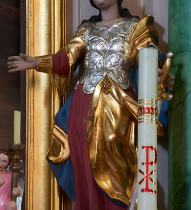 Zdjęcie nr 12: Nastawa ołtarzowa architektoniczna, dwukondygnacyjna ze zwieńczeniem, obie kondygnacje trójosiowe. Ołtarz murowany, prostopadłościenny, mensa z kamiennym portatylem. Antepedium dekorowane malowaną iluzjonistycznie prostokątną płyciną z wypukłymi krótszymi bokami. Na ołtarzu tabernakulum w formie drewnianej skrzynki ujętej kolumienkami podtrzymującymi gzyms. Do niego wbudowana drewniana skrzynka obita metalową blachą, z drzwiczkami w kształcie stojącego prostokąta, ujętego ramą, z wizerunkiem krzyża, winnego grona, kłosów zbóż i kielicha z hostią w polu. Całość flankowana uszami utworzonymi z cęg i kratki. Na tabernakulum tron wystawienia przyjmujący postać glorii promienistej, z parą aniołów unoszącą nad nią koronę zamkniętą. Tron flankowany dwoma klęczącymi aniołkami trzymającymi lichtarze ze świecami. Pierwsza kondygnacja na dwustrefowym cokole, w górnej partii z wyodrębnionymi prostopadłościanami, dekorowanymi płycinami z ornamentem roślinnym. Osie wydzielone czterema kolumnami o kapitelach kompozytowych, dźwigających pełne belkowanie z silnie wysuniętym gzymsem, wyłamane na ich osi oraz ustawione pod kątem na zewnątrz. Fryz dekorowany medalionem z monogramem IHS, uskrzydlonymi główkami anielskimi i ornamentem roślinnym. W polu środkowym wnęka w formie stojącego prostokąta, ujęta profilowaną ramą, z obrazem św. Jakuba. Wnęka flankowana figurami św. Katarzyny Aleksandryjskiej i św. Barbary ustawionymi na cokołach. Na osiach bocznych rzeźby św. Jana Chrzciciela i św. Andrzeja na cokołach. Pierwsza kondygnacja flankowana uszami utworzonymi z wici roślinnej i kratki. Druga kondygnacja na cokole z wyodrębnionymi prostopadłościanami, dekorowanymi płycinami z ornamentem roślinnym. Osie wydzielone czterema kolumnami o kapitelach kompozytowych, dźwigającymi pełne belkowanie, wyłamane na ich osi. Wewnętrzna para zwrócona pod kątem do środka, para skrajna na zewnątrz. Fryz dekorowany uskrzydlonymi główkami anielskimi. W polu obraz św. Józefa z Dzieciątkiem w formie stojącego prostokąta zamkniętego łukiem odcinkowym, ujęty profilowaną ramą. Na osiach bocznych ustawione figury niezidentyfikowanej świętej i św. Jadwigi (?). Na skraju belkowania pierwszej kondygnacji umiejscowione rzeźby Marii i św. Jana. Druga kondygnacja flankowana uszami utworzonymi z wici roślinnej. Zwieńczenie w kształcie zbliżonym do leżącego prostokąta, o wklęsłych bokach, zamkniętego łukiem odcinkowym nadwieszonym. W polu grupa rzeźbiarska Koronacji Marii, w której postacie unoszą się na obłokach, nad nimi zaś znajduje się gołębica Ducha Świętego w glorii. Na belkowaniu drugiej kondygnacji ustawione dwa klęczące na obłokach aniołki oraz figury św. Stefana i św. Władysława. Struktura polichromowana w kolorze beżowym, z bladoróżowymi detalami; kolumny malowane na sposób imitujący marmoryzacje w kolorze zielonym; profile i ornamentyka złocone. 

