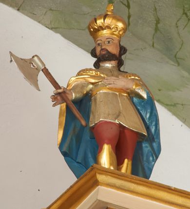 Zdjęcie nr 14: Nastawa ołtarzowa architektoniczna, dwukondygnacyjna ze zwieńczeniem, obie kondygnacje trójosiowe. Ołtarz murowany, prostopadłościenny, mensa z kamiennym portatylem. Antepedium dekorowane malowaną iluzjonistycznie prostokątną płyciną z wypukłymi krótszymi bokami. Na ołtarzu tabernakulum w formie drewnianej skrzynki ujętej kolumienkami podtrzymującymi gzyms. Do niego wbudowana drewniana skrzynka obita metalową blachą, z drzwiczkami w kształcie stojącego prostokąta, ujętego ramą, z wizerunkiem krzyża, winnego grona, kłosów zbóż i kielicha z hostią w polu. Całość flankowana uszami utworzonymi z cęg i kratki. Na tabernakulum tron wystawienia przyjmujący postać glorii promienistej, z parą aniołów unoszącą nad nią koronę zamkniętą. Tron flankowany dwoma klęczącymi aniołkami trzymającymi lichtarze ze świecami. Pierwsza kondygnacja na dwustrefowym cokole, w górnej partii z wyodrębnionymi prostopadłościanami, dekorowanymi płycinami z ornamentem roślinnym. Osie wydzielone czterema kolumnami o kapitelach kompozytowych, dźwigających pełne belkowanie z silnie wysuniętym gzymsem, wyłamane na ich osi oraz ustawione pod kątem na zewnątrz. Fryz dekorowany medalionem z monogramem IHS, uskrzydlonymi główkami anielskimi i ornamentem roślinnym. W polu środkowym wnęka w formie stojącego prostokąta, ujęta profilowaną ramą, z obrazem św. Jakuba. Wnęka flankowana figurami św. Katarzyny Aleksandryjskiej i św. Barbary ustawionymi na cokołach. Na osiach bocznych rzeźby św. Jana Chrzciciela i św. Andrzeja na cokołach. Pierwsza kondygnacja flankowana uszami utworzonymi z wici roślinnej i kratki. Druga kondygnacja na cokole z wyodrębnionymi prostopadłościanami, dekorowanymi płycinami z ornamentem roślinnym. Osie wydzielone czterema kolumnami o kapitelach kompozytowych, dźwigającymi pełne belkowanie, wyłamane na ich osi. Wewnętrzna para zwrócona pod kątem do środka, para skrajna na zewnątrz. Fryz dekorowany uskrzydlonymi główkami anielskimi. W polu obraz św. Józefa z Dzieciątkiem w formie stojącego prostokąta zamkniętego łukiem odcinkowym, ujęty profilowaną ramą. Na osiach bocznych ustawione figury niezidentyfikowanej świętej i św. Jadwigi (?). Na skraju belkowania pierwszej kondygnacji umiejscowione rzeźby Marii i św. Jana. Druga kondygnacja flankowana uszami utworzonymi z wici roślinnej. Zwieńczenie w kształcie zbliżonym do leżącego prostokąta, o wklęsłych bokach, zamkniętego łukiem odcinkowym nadwieszonym. W polu grupa rzeźbiarska Koronacji Marii, w której postacie unoszą się na obłokach, nad nimi zaś znajduje się gołębica Ducha Świętego w glorii. Na belkowaniu drugiej kondygnacji ustawione dwa klęczące na obłokach aniołki oraz figury św. Stefana i św. Władysława. Struktura polichromowana w kolorze beżowym, z bladoróżowymi detalami; kolumny malowane na sposób imitujący marmoryzacje w kolorze zielonym; profile i ornamentyka złocone. 

