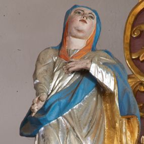 Zdjęcie nr 1: Rzeźba pełna, ustawiona na nieregularnej podstawie. Maria ukazana frontalnie, z uniesioną głową, w kontrapoście. Lewą rękę kładzie na piersi, prawą wyciąga w dół. Twarz ma pełną, z oczami skierowanymi w górę, prostym nosie i małych ustach. Wokół głowy ma pomarańczową podwikę. Ubrana jest w srebrzoną suknię oraz niebieski płaszcz ze złoconą podszewką zarzucony na głowę i ramiona. Polichromia ciała naturalistyczna.


 